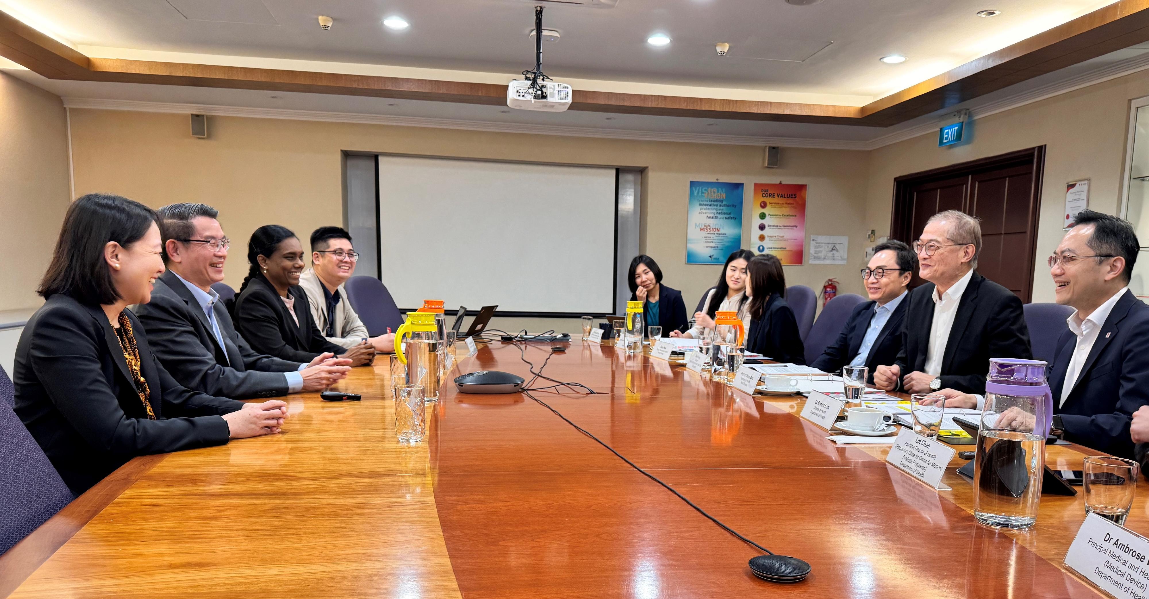 The Secretary for Health, Professor Lo Chung-mau (second right), and his delegation meet with the founding Executive Director of the Centre of Regulatory Excellence at Duke-NUS Medical School, Professor John Lim (second left), in Singapore today (August 13). The Director of Health, Dr Ronald Lam (first right), also attends the meeting.