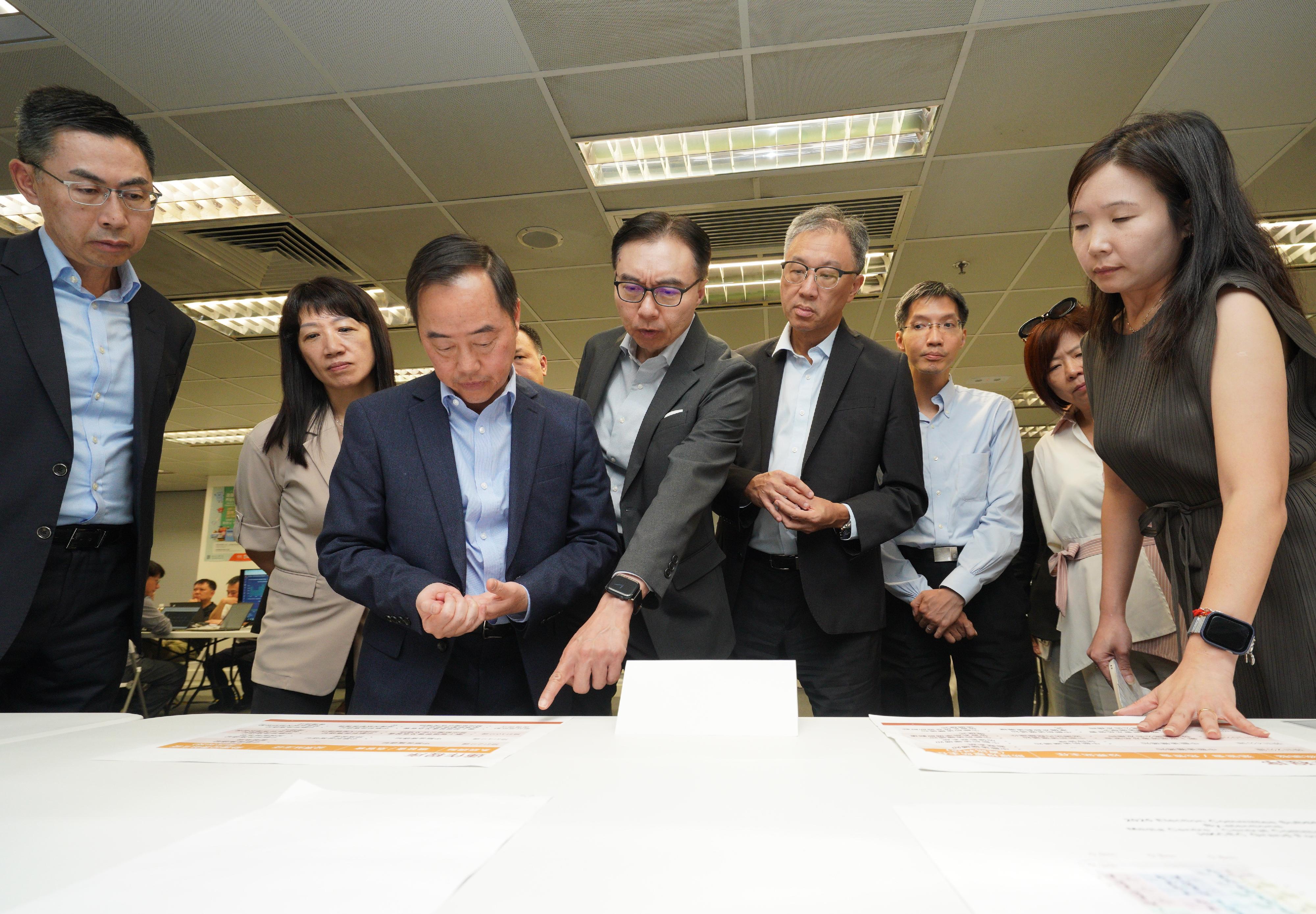 選舉事務處聯同數字政策辦公室今日（八月十三日）進行電子選民登記冊系統技術支援的常規及應急安排演練，為九月七日舉行的選舉委員會界別分組補選以及十二月七日舉行的立法會換屆選舉作充分準備和周詳部署。圖示選舉管理委員會主席陸啟康法官（右四）、數字政策專員黃志光（左三）、選舉事務處總選舉事務主任陳淑華（左二）、技術諮詢委員會召集人李惠光（左四）及技術諮詢委員會成員視察主動系統監察措施和模擬在不同情境下相關應變方案的執行情況。
