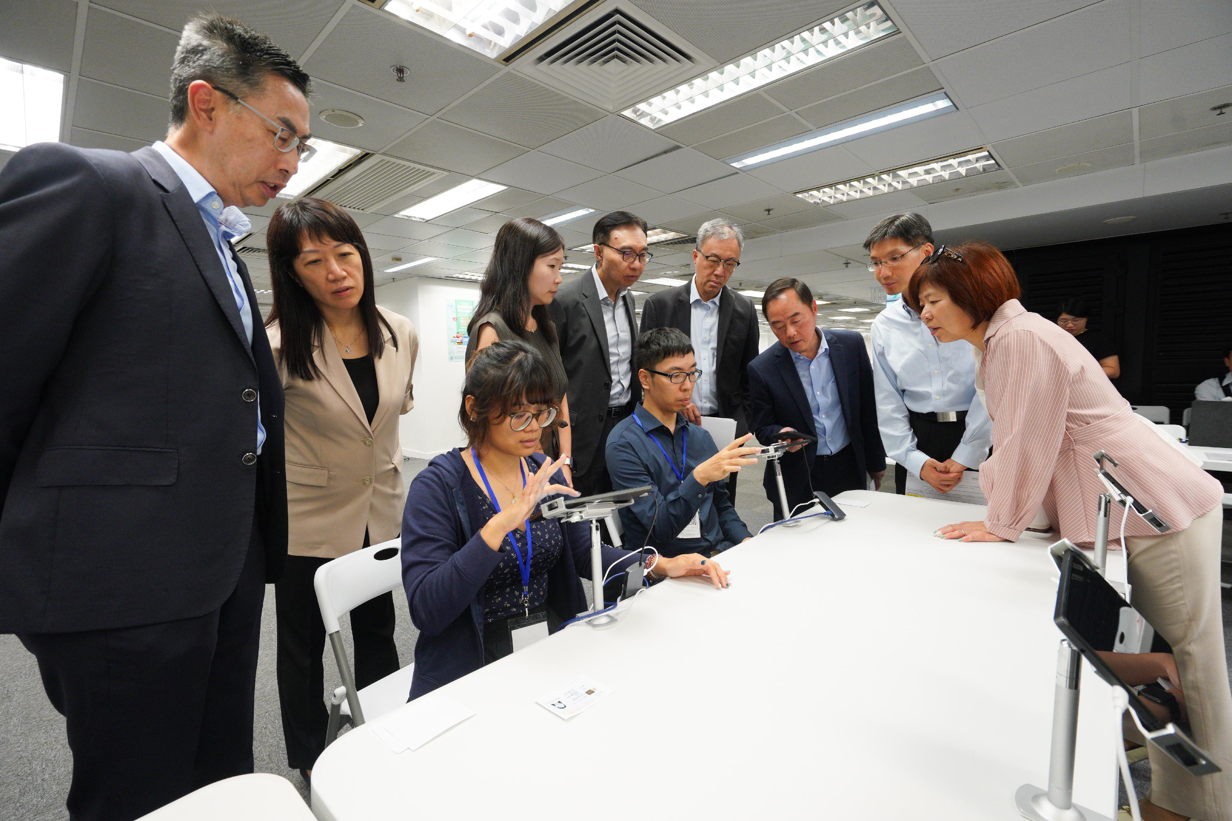 選舉事務處聯同數字政策辦公室今日（八月十三日）進行電子選民登記冊系統技術支援的常規及應急安排演練，為九月七日舉行的選舉委員會界別分組補選以及十二月七日舉行的立法會換屆選舉作充分準備和周詳部署。圖示選舉管理委員會主席陸啟康法官（後排右三）、數字政策專員黃志光（後排右二）、選舉事務處總選舉事務主任陳淑華（後排左二）、技術諮詢委員會召集人李惠光（後排左四）及技術諮詢委員會成員視察演練，模擬啓動應變方案後以最短時間恢復系統運作。
