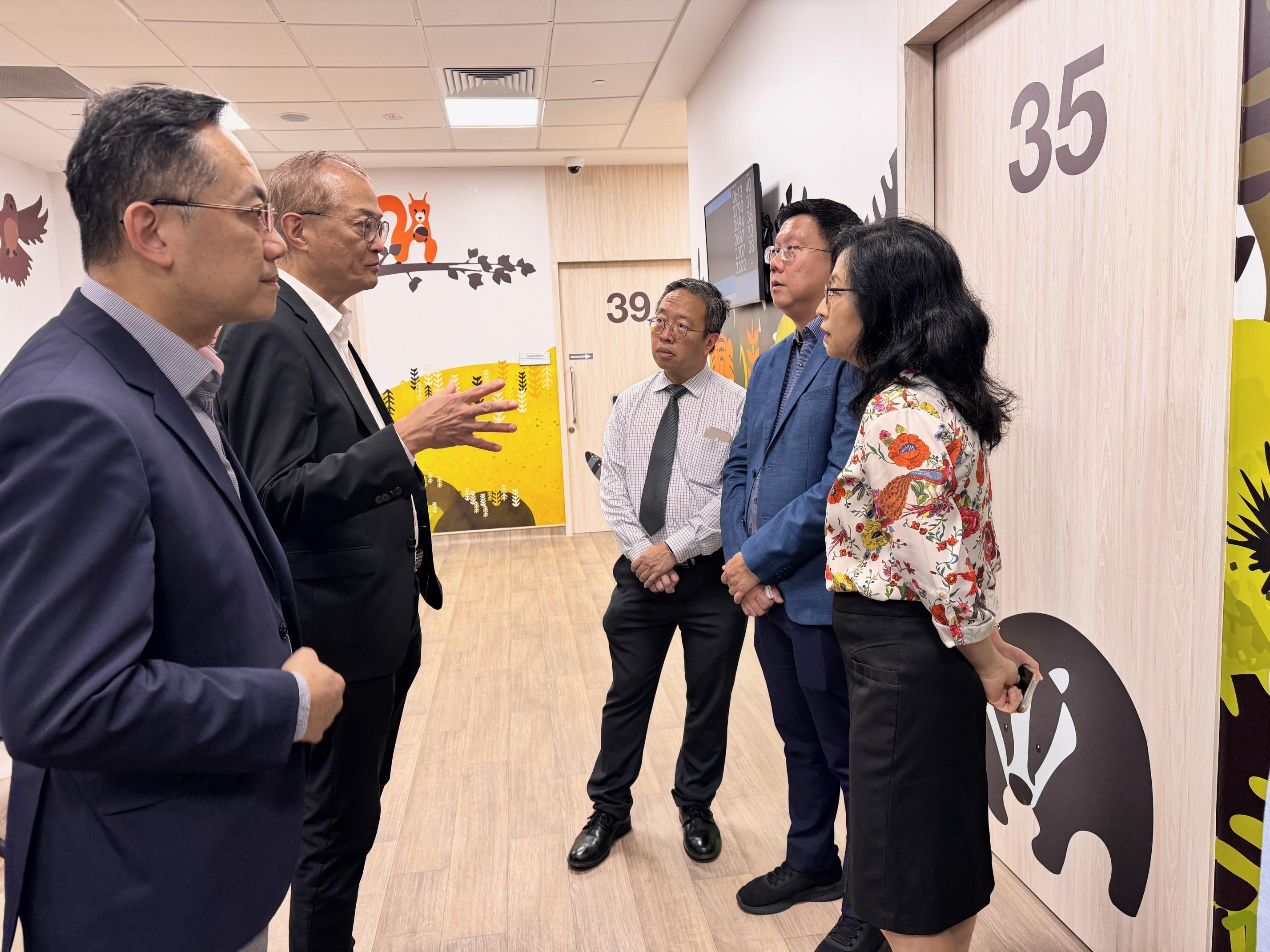 The Secretary for Health, Professor Lo Chung-mau (second left), and the Director of Health, Dr Ronald Lam (first left), visit the National Healthcare Group Sembawang Polyclinic in Singapore today (August 14).

