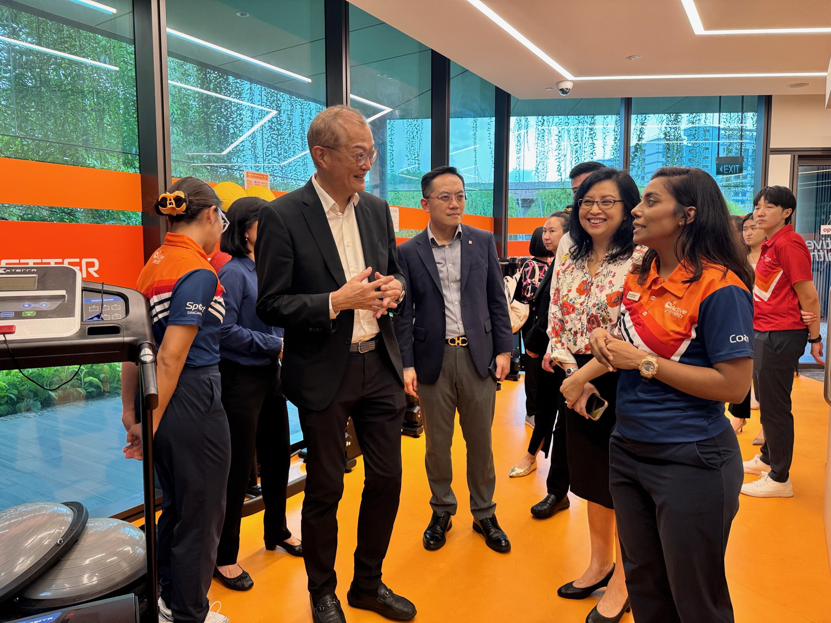 The Secretary for Health, Professor Lo Chung-mau (front row, fourth right), and the Director of Health, Dr Ronald Lam (front row, third right), visit the National Healthcare Group Sembawang Polyclinic in Singapore today (August 14).

