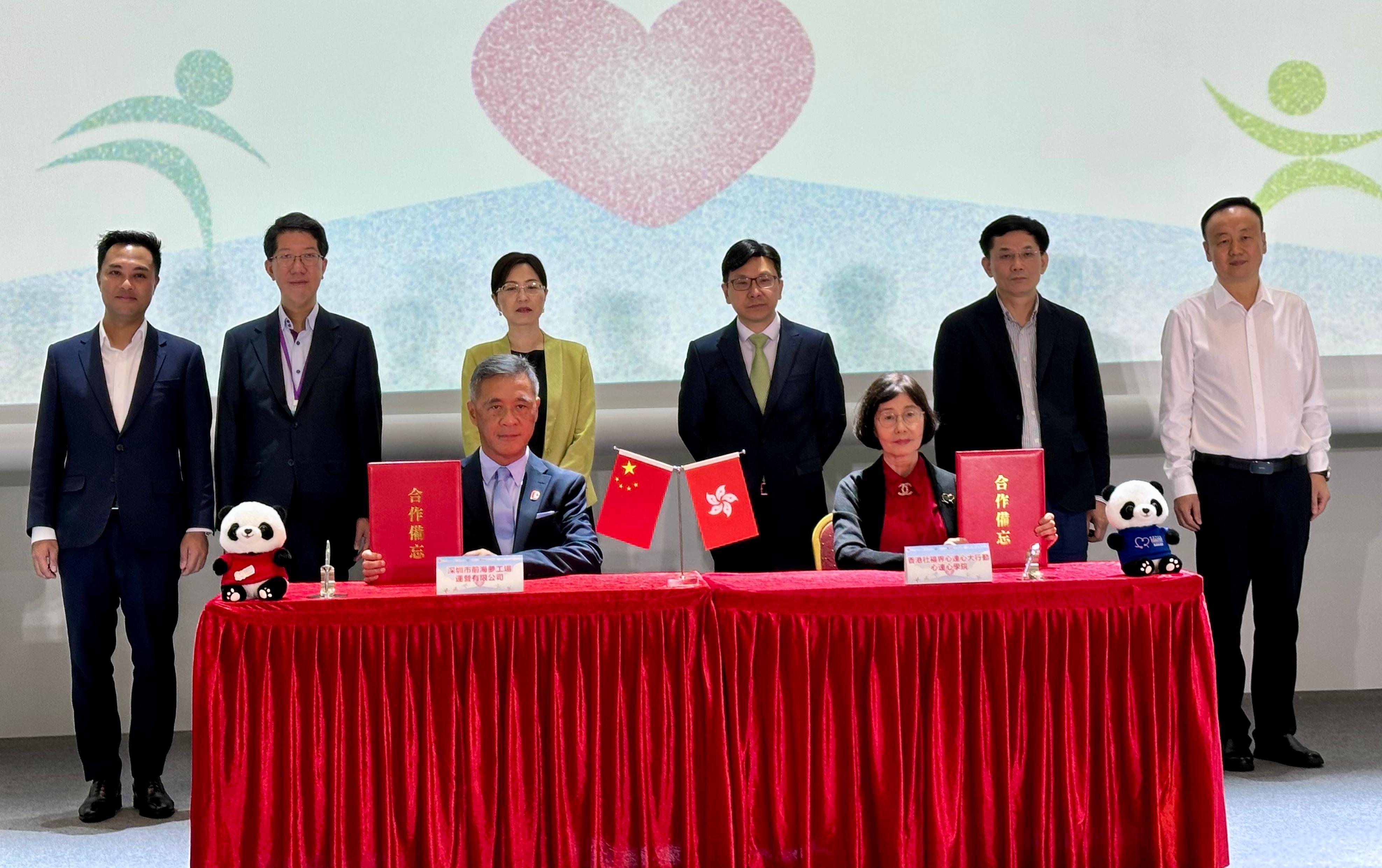 勞工及福利局局長孫玉菡今日（八月十八日）為香港青年看前海：「心連心」共創明天暨參觀前海國際交流合作平台啓動禮主禮。圖示孫玉菡（後排右三）、深圳市前海合作區黨工委副書記梁珂（後排左三）、中央人民政府駐香港特別行政區聯絡辦公室社會工作部副部長周和博士（後排右二）和社會福利署署長杜永恒（後排左二）一同見證前海夢工場運營公司總經理莫偉軒（前排左）與心連心學院院長譚贛蘭教授（前排右）共同簽署合作備忘錄。
