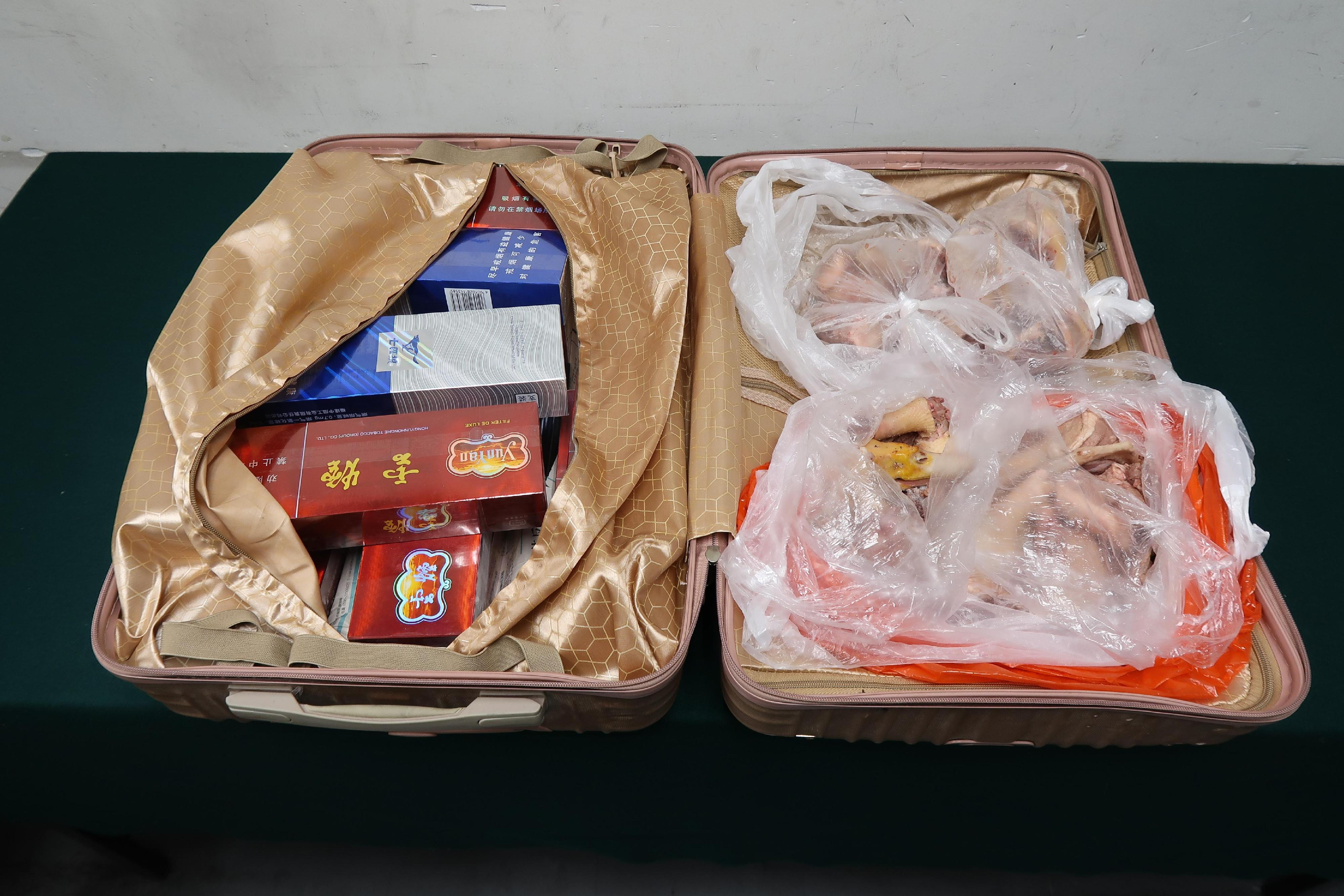 一名四十九歲抵港女旅客因管有未完稅香煙、未有向海關人員作出申報及非法進口生肉，違反《應課稅品條例》及《進口野味、肉類、家禽及蛋類規例》，今日（八月十八日）在屯門裁判法院被判處監禁三個月及罰款五百元。圖示在其行李箱內檢獲的未完稅香煙及非法進口生肉。