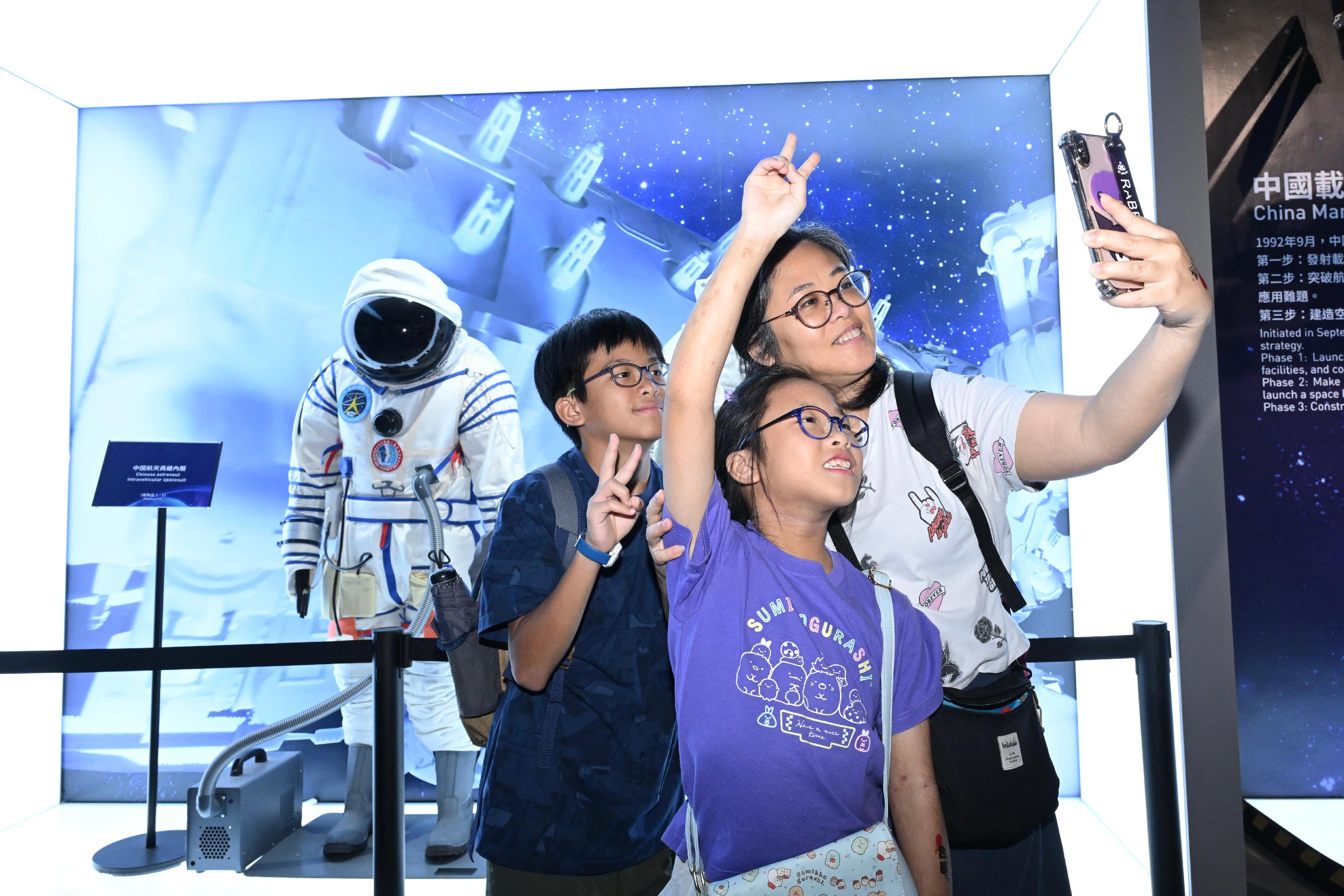 The "Bank of China (Hong Kong) Presents: National Development and Achievements Series - Endless Exploration: The Journey of Chinese Aerospace, Aviation and Navigation" exhibition, currently being held at the Hong Kong Science Museum, welcomed its 100 000th visitor today (August 19). Photo shows visitors touring the exhibition.
