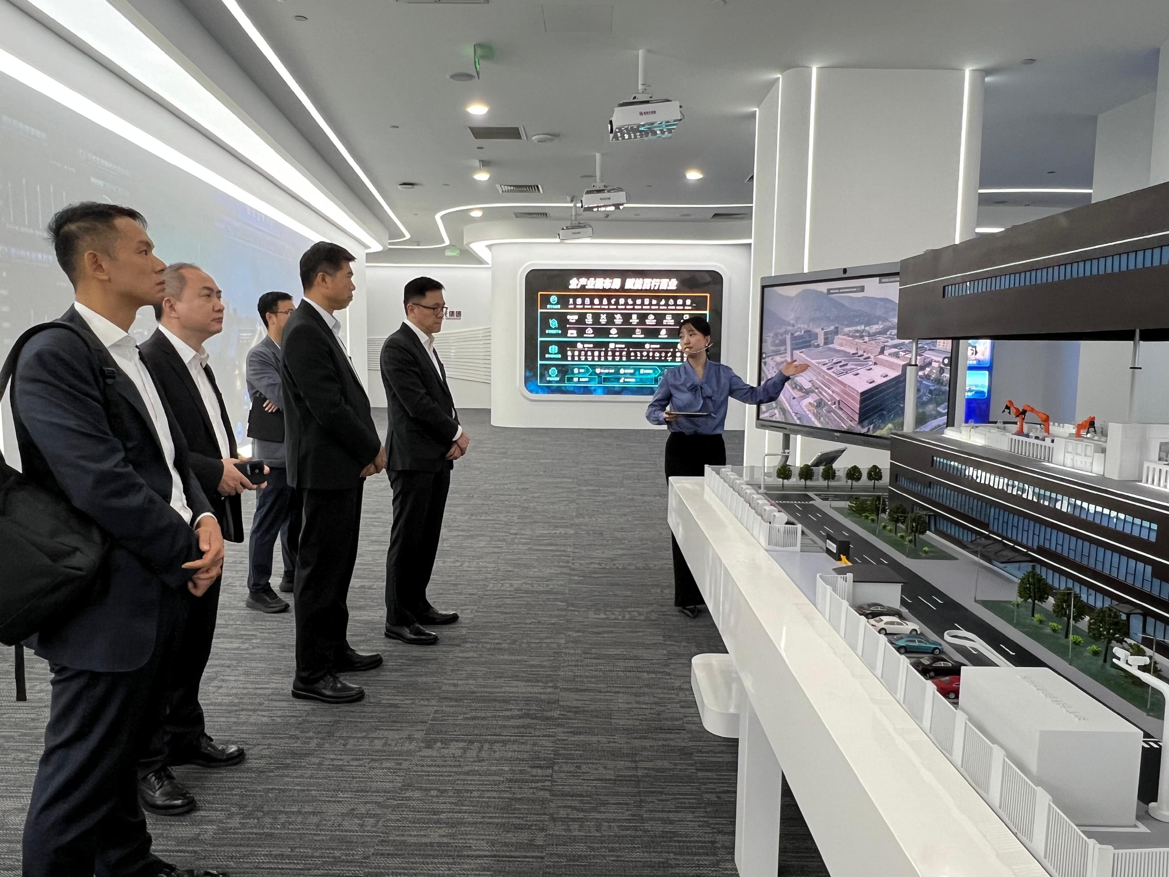 The Secretary for Innovation, Technology and Industry, Professor Sun Dong (second right), visited the Tsinghua Unigroup in Beijing today (August 19) and toured the group's exhibition centre and received a briefing on its achievements in relevant semiconductor chip technology and industry development. Looking on is the Commissioner for Industry (Innovation and Technology), Dr Ge Ming (second left).