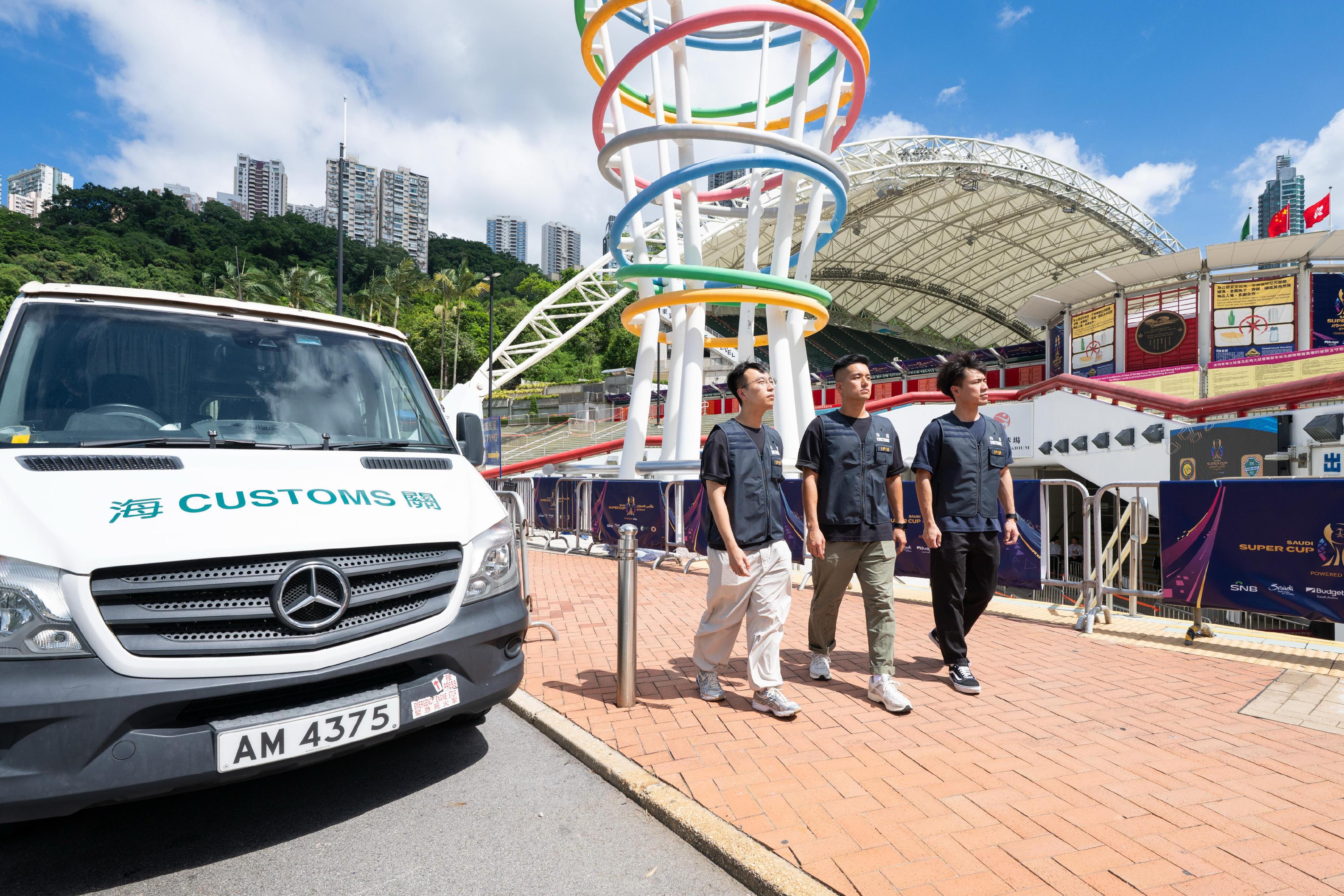Hong Kong Customs, during major international sports events, conducted a special operation against the sale of counterfeit goods by mobile hawkers on July 26 and 31, August 19 and 20, and today (August 23). During the operation, over 1 200 items of suspected counterfeit goods with an estimated market value of about $210,000 were seized. Photo shows Customs officers patrolling in the vicinity of the Hong Kong Stadium.
 