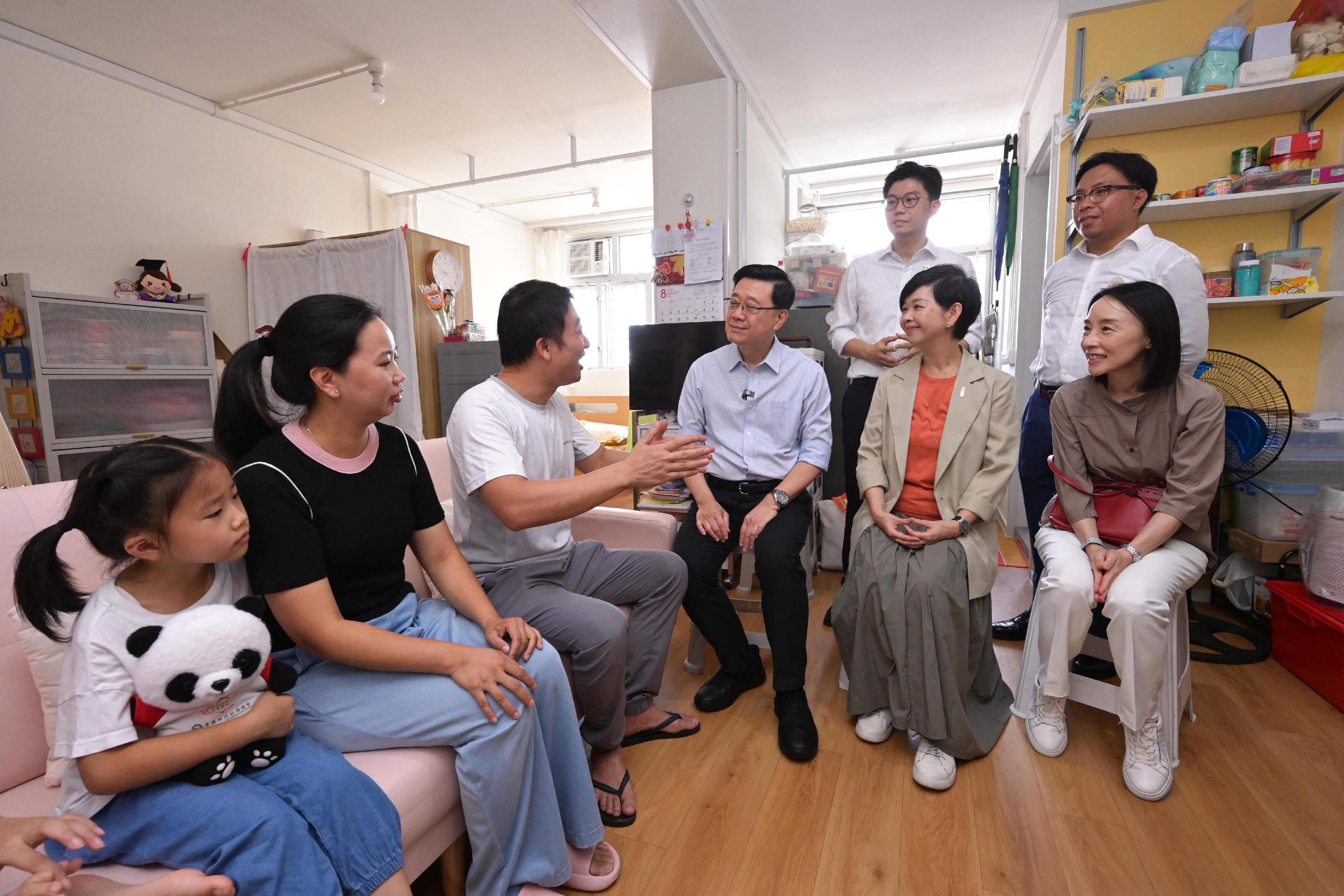 行政長官李家超今日（八月二十三日）到訪觀塘區，就新一份《施政報告》聽取市民意見。圖示李家超（前排右三）和房屋局局長何永賢（前排右二）探訪一個居住在「簡約公屋」的家庭。

