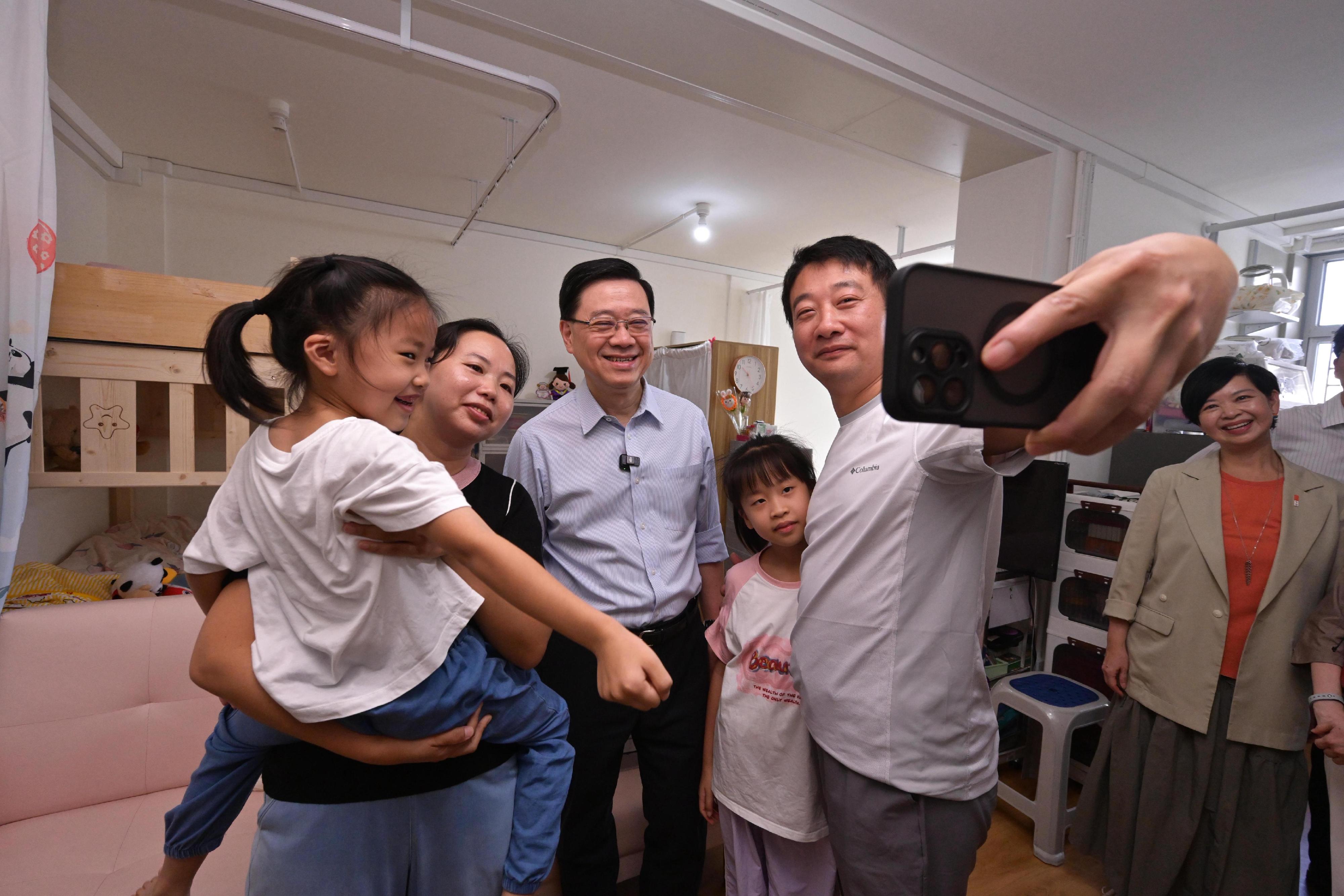 行政長官李家超今日（八月二十三日）到訪觀塘區，就新一份《施政報告》聽取市民意見。圖示李家超（左三）和房屋局局長何永賢（右一）探訪一個居住在「簡約公屋」的家庭。

