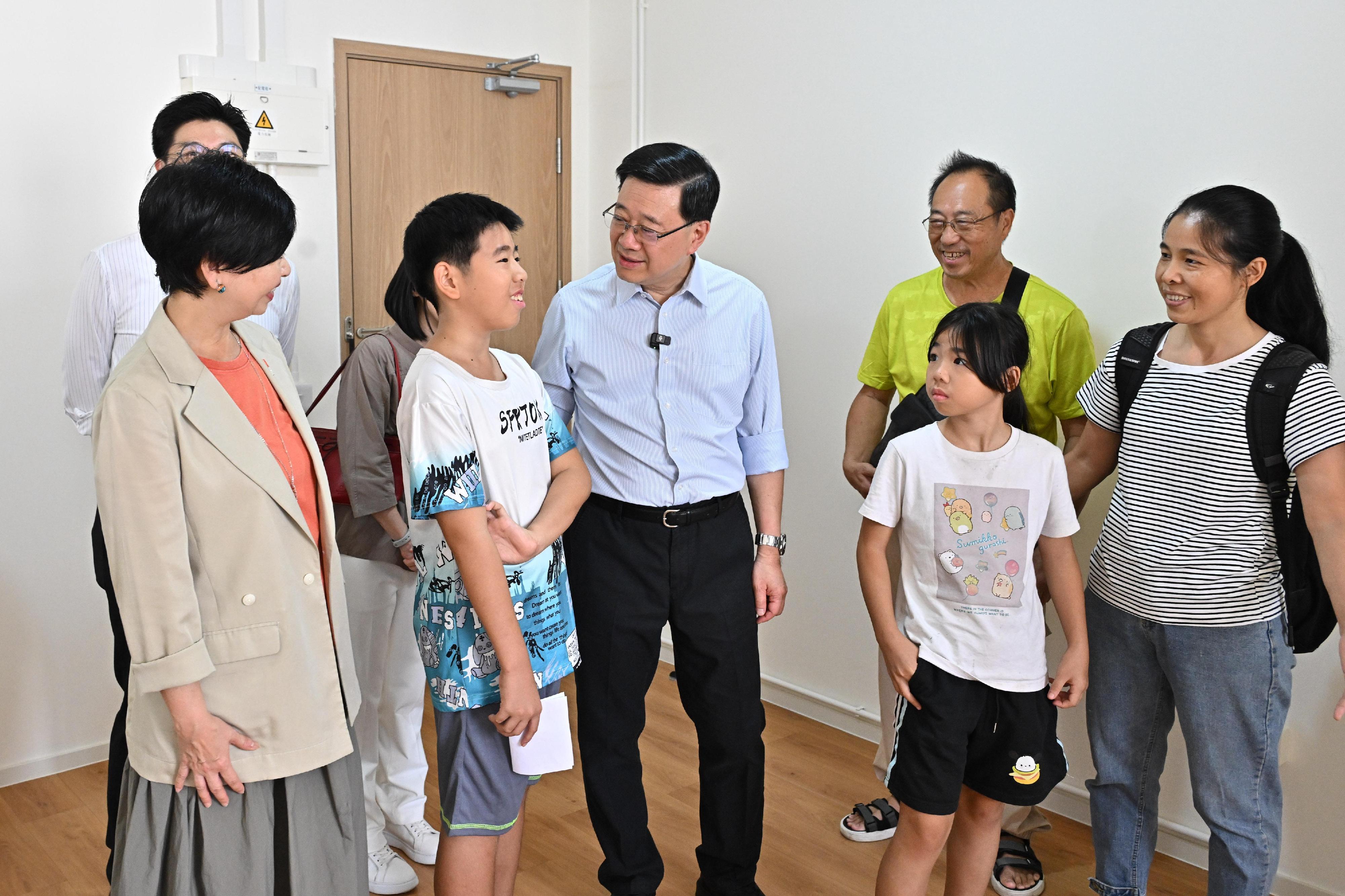 行政長官李家超今日（八月二十三日）到訪觀塘區，就新一份《施政報告》聽取市民意見。圖示李家超（前排中）在房屋局局長何永賢（前排左一）陪同下參觀「簡約公屋」新單位，並與住戶交流。

