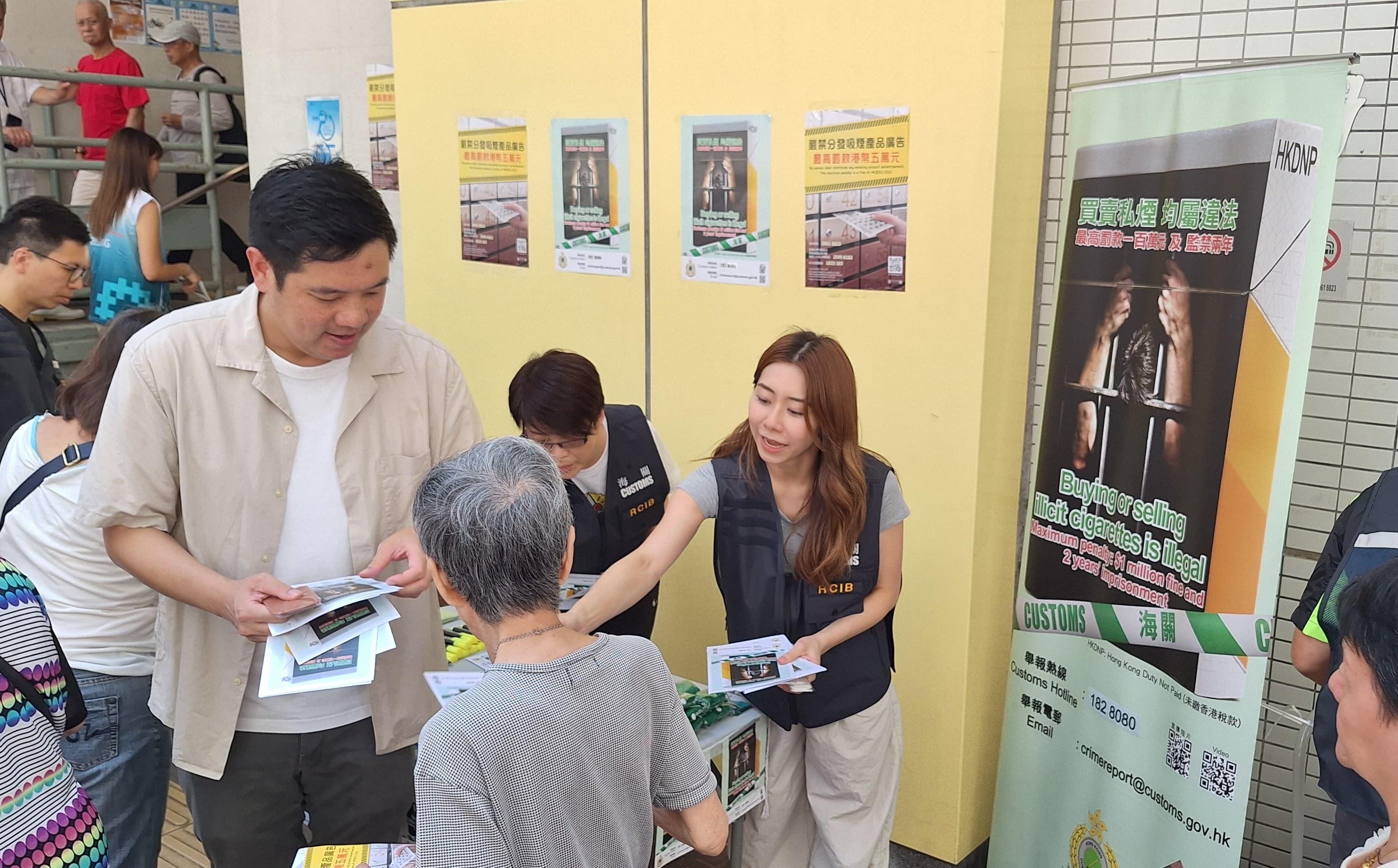 Hong Kong Customs conducted a joint anti-illicit cigarette publicity campaign with members of the Tsuen Wan District Council, the Tobacco and Alcohol Control Office of the Department of Health, the Housing Department and the Community Care Team at Lei Muk Shue Estate in Tsuen Wan today (August 27). Photo shows a Customs officer and a member of the Tsuen Wan District Council promoting anti-illicit cigarette messages to a resident.