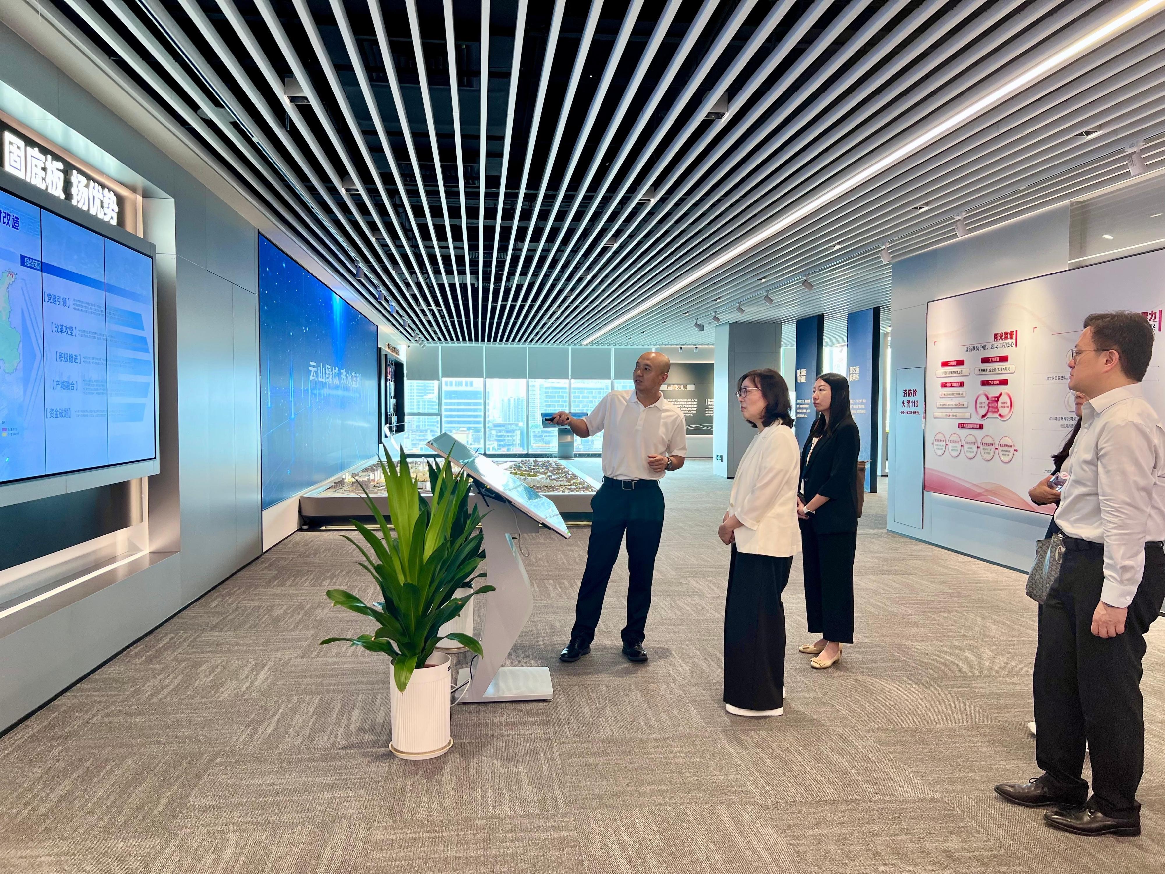 The Secretary for Development, Ms Bernadette Linn, visited the redevelopment project of urban villages at Songxi District in Guangzhou today (August 27). Photo shows Ms Linn (second left) being briefed on the development of the district concerned and urban renewal projects during a visit to an exhibition hall showcasing the redevelopment project of urban villages.