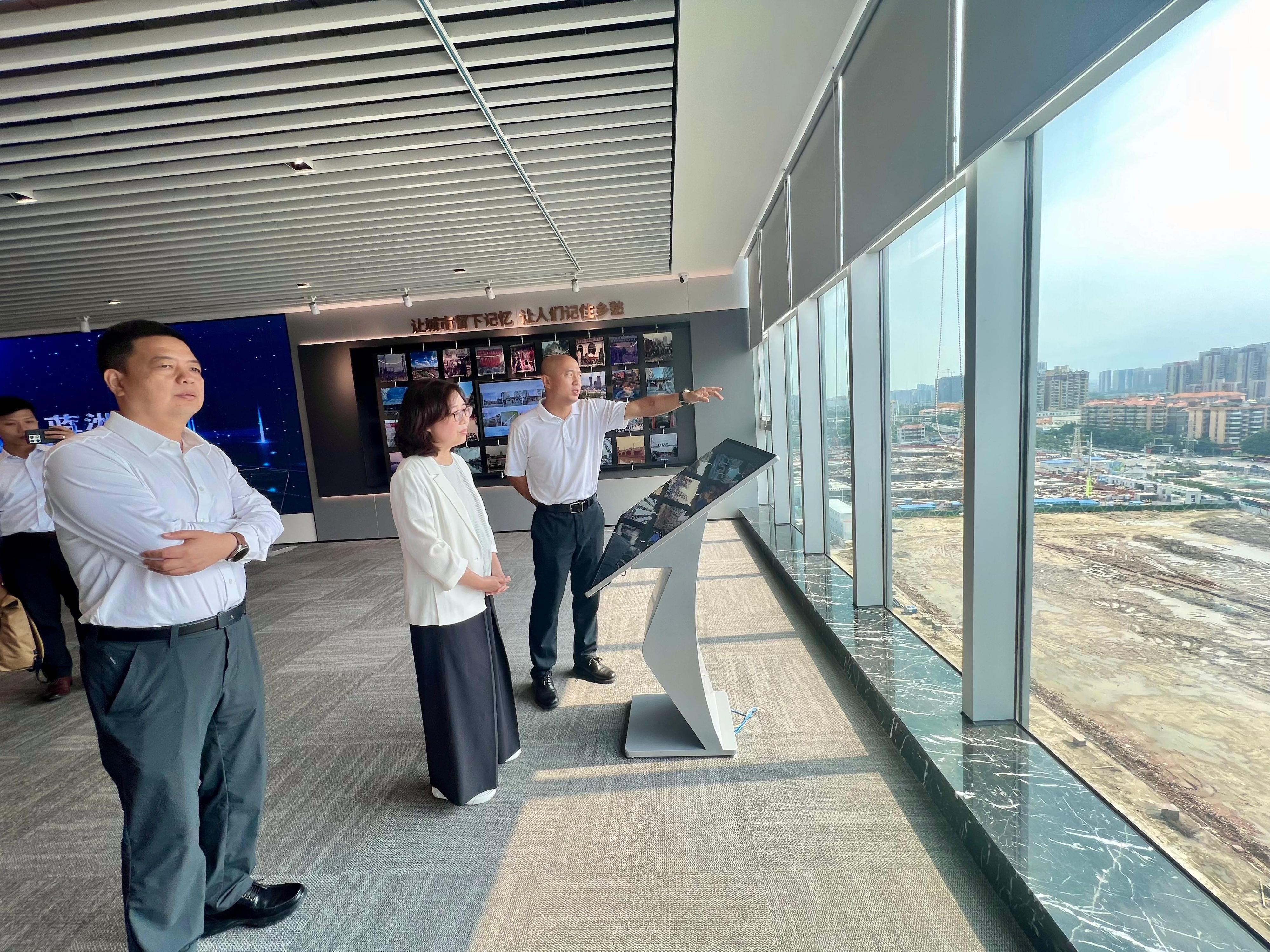The Secretary for Development, Ms Bernadette Linn, visited the redevelopment project of urban villages at Songxi District in Guangzhou today (August 27). Photo shows Ms Linn (second left) being briefed on the development of the district concerned and urban renewal projects during a visit to an exhibition hall showcasing the redevelopment project of urban villages.