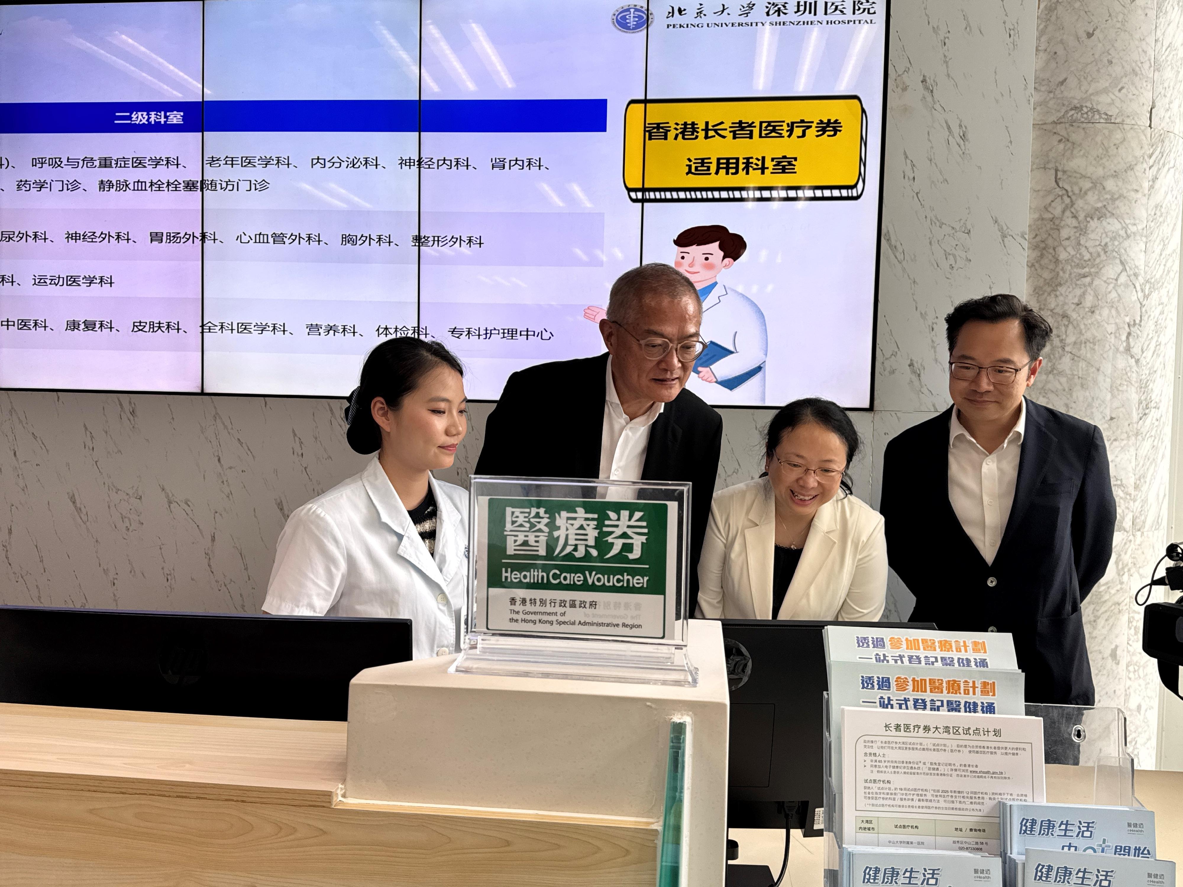 醫務衞生局（醫衞局）局長盧寵茂教授今日（八月二十八日）到北京大學深圳醫院視察首日推行「長者醫療券大灣區試點計劃」的運作安排。圖示盧寵茂教授（左二）和醫衞局副秘書長李力綱（右一）聽取院方講解香港長者就醫流程。