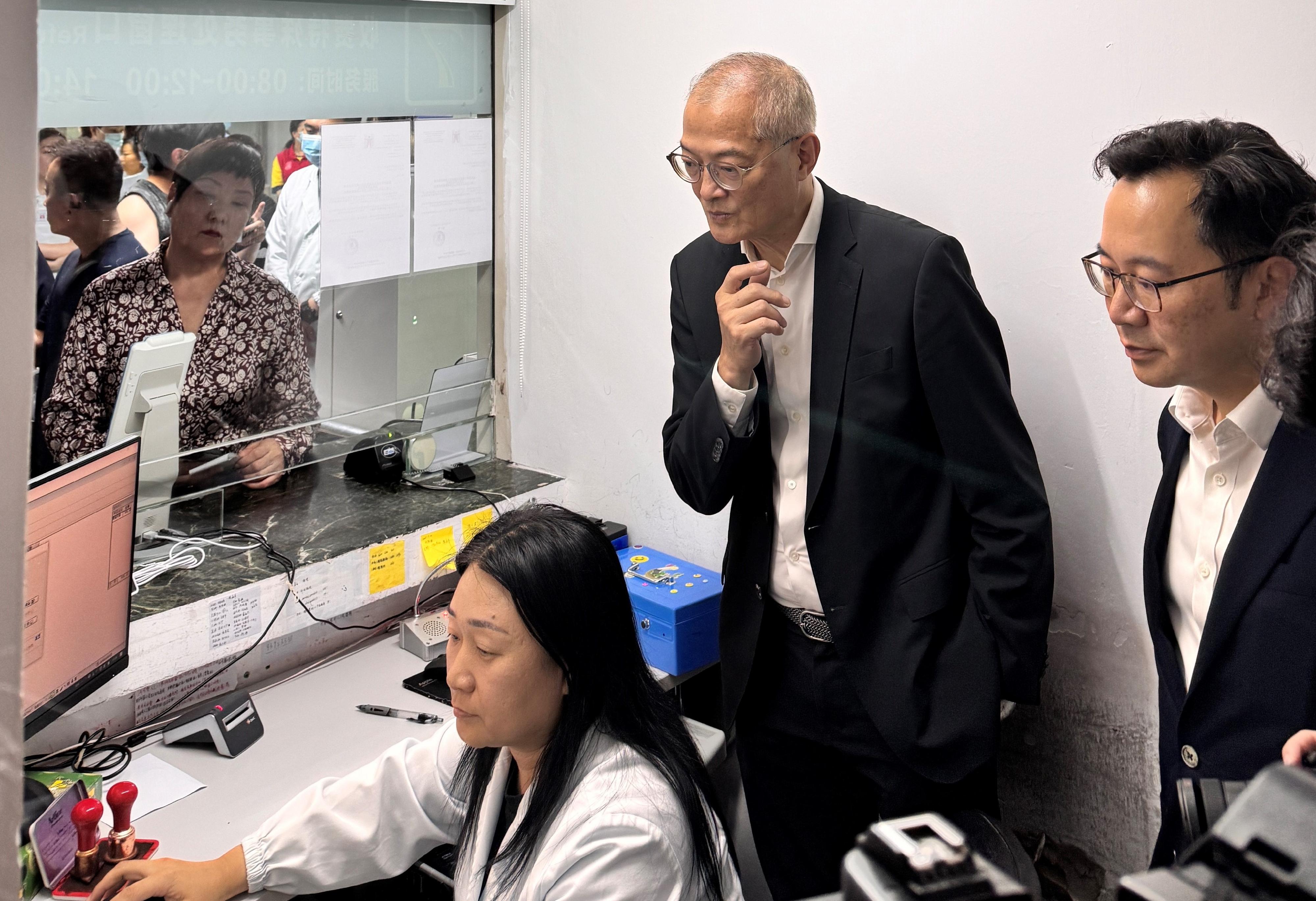 醫務衞生局（醫衞局）局長盧寵茂教授今日（八月二十八日）到北京大學深圳醫院視察首日推行「長者醫療券大灣區試點計劃」的運作安排。圖示盧寵茂教授（中）和醫衞局副秘書長李力綱（右）聽取院方講解香港長者結帳流程。