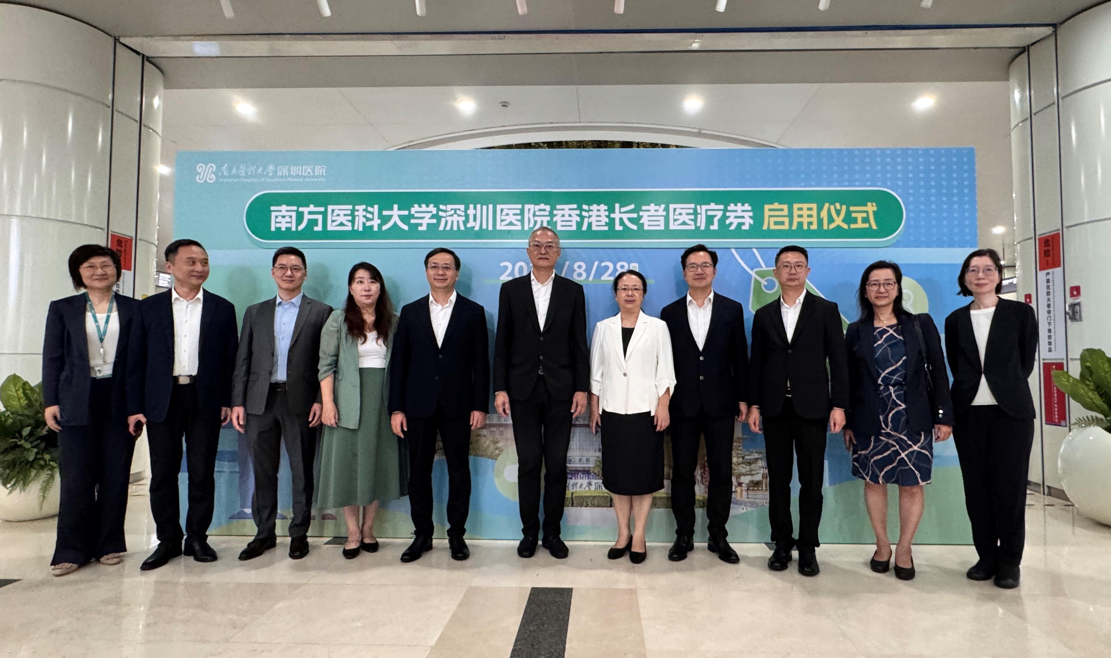 醫務衞生局（醫衞局）局長盧寵茂教授今日（八月二十八日）到南方醫科大學深圳醫院（南醫大深圳醫院）視察首日推行「長者醫療券大灣區試點計劃」的運作安排。圖示盧寵茂教授（中）、醫衞局副秘書長李力綱（右四）、局長辦公室高級顧問樊敬文醫生（右三），聯同深圳市衞生健康委員會副主任文正萬（左五）和周麗萍（右五），以及南醫大深圳醫院院長周宏偉教授（左二）、副院長陳燁教授（右二）和其他人員合照。