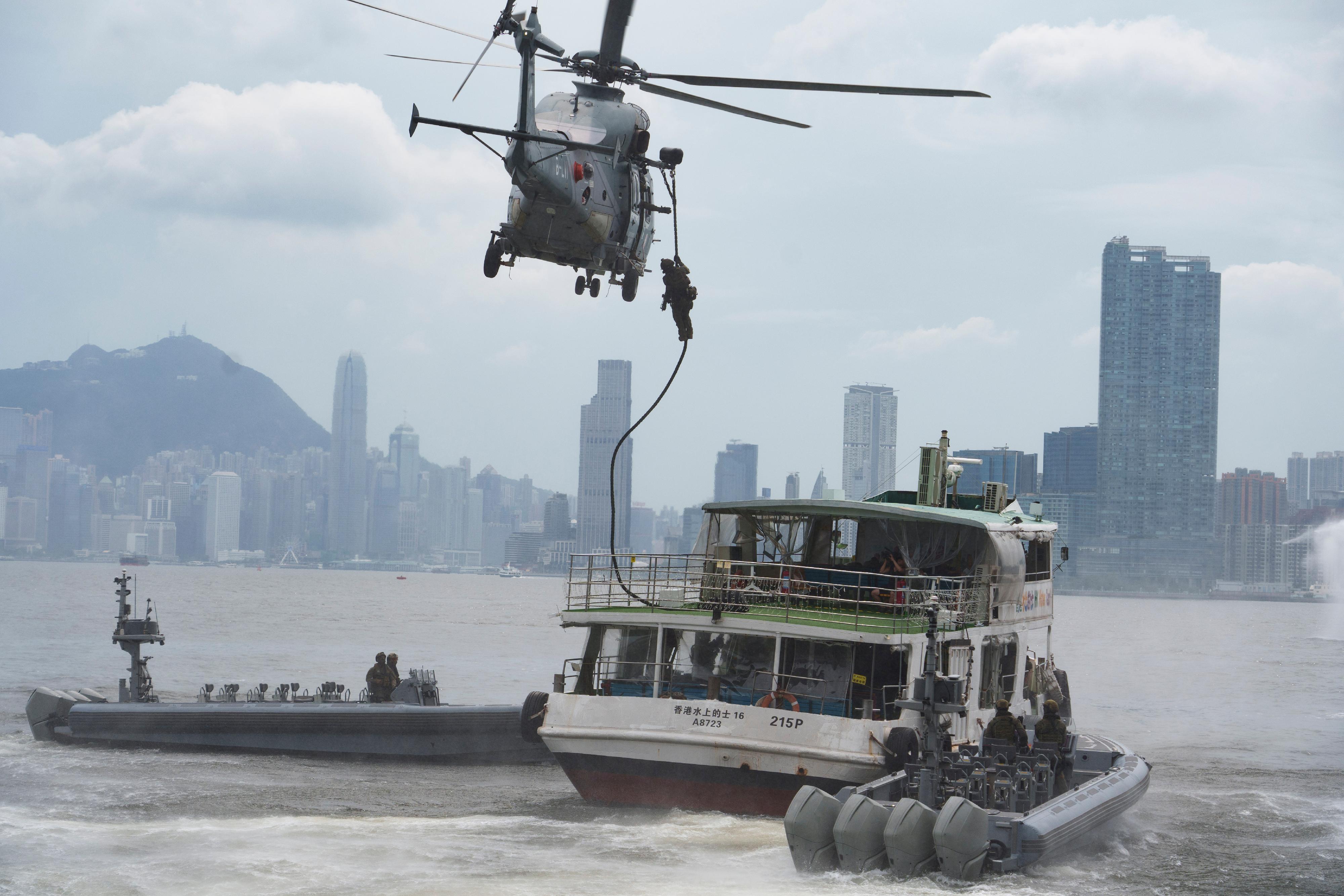 The Inter-departmental Counter Terrorism Unit conducted a large-scale interdepartmental counter-terrorism exercise codenamed BRAVELIGHT at the Kai Tak Cruise Terminal today (August 28). Photo shows officers of the Police Special Duties Unit boarding a passenger ship taken hostage by terrorists using small boats and a Government Flying Service helicopter in the exercise.
