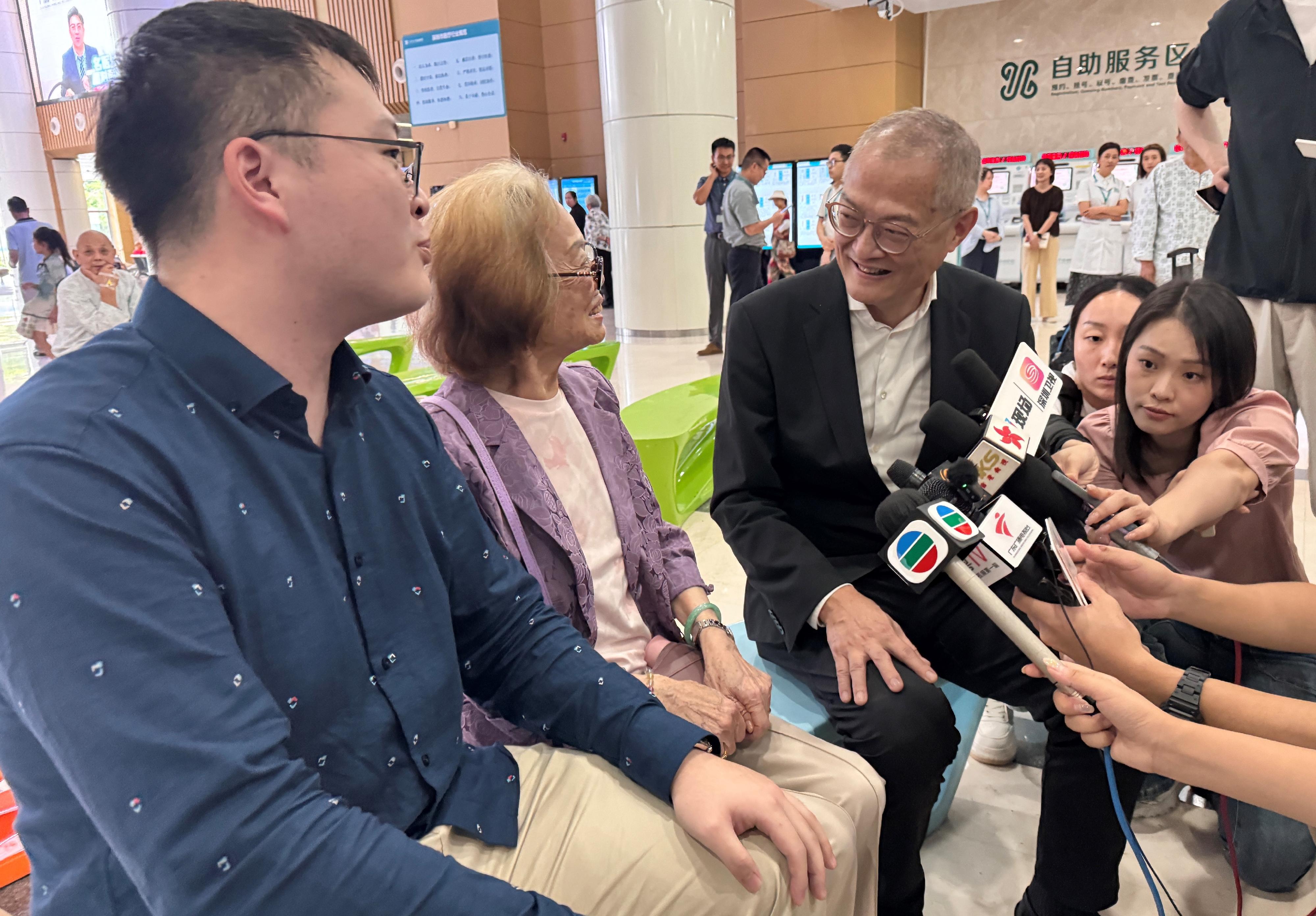 The Secretary for Health, Professor Lo Chung-mau, visited Shenzhen Hospital of Southern Medical University today (August 28) to inspect the operational arrangements on the first day of the service launch under the Elderly Health Care Voucher Greater Bay Area Pilot Scheme. Photo shows Professor Lo (second right) chatting with an elderly citizen from Hong Kong who shared her experience in using the Pilot Scheme services at the hospital.
