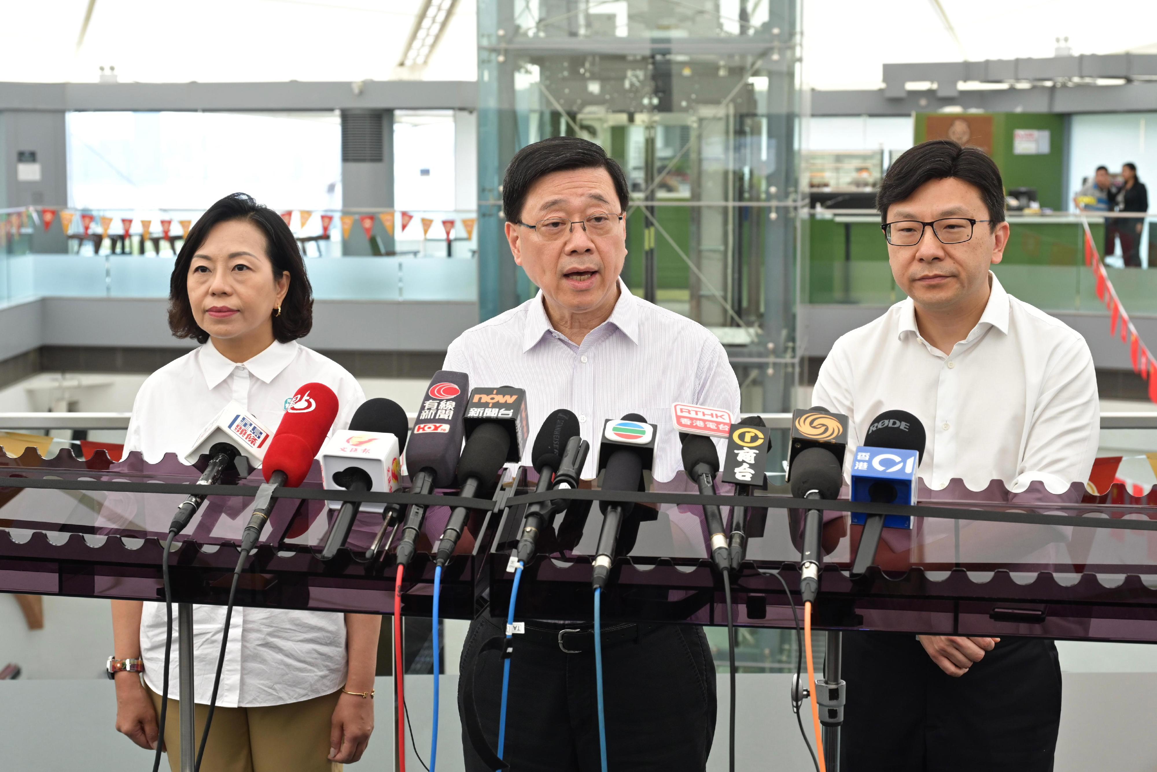 The Chief Executive, Mr John Lee (centre), accompanied by the Secretary for Home and Youth Affairs, Miss Alice Mak (left); and the Secretary for Labour and Welfare, Mr Chris Sun (right), meets the media after visiting Eastern District today (August 30) to gather public views on the upcoming Policy Address.