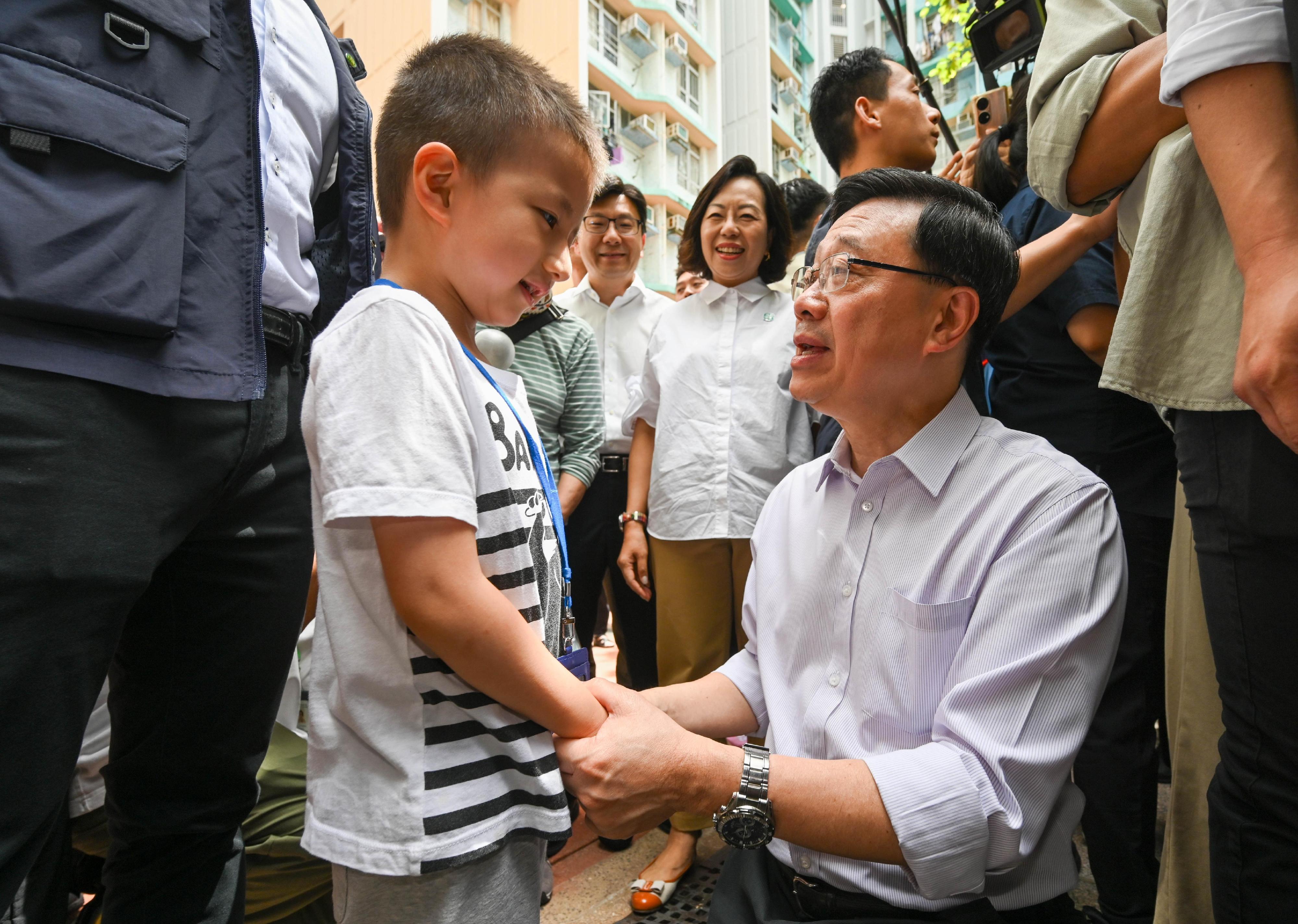 The Chief Executive, Mr John Lee, visited Eastern District today (August 30) to gather public views on the upcoming Policy Address. Photo shows Mr Lee (first right) interacting with a member of the public at Oi Tung Estate.