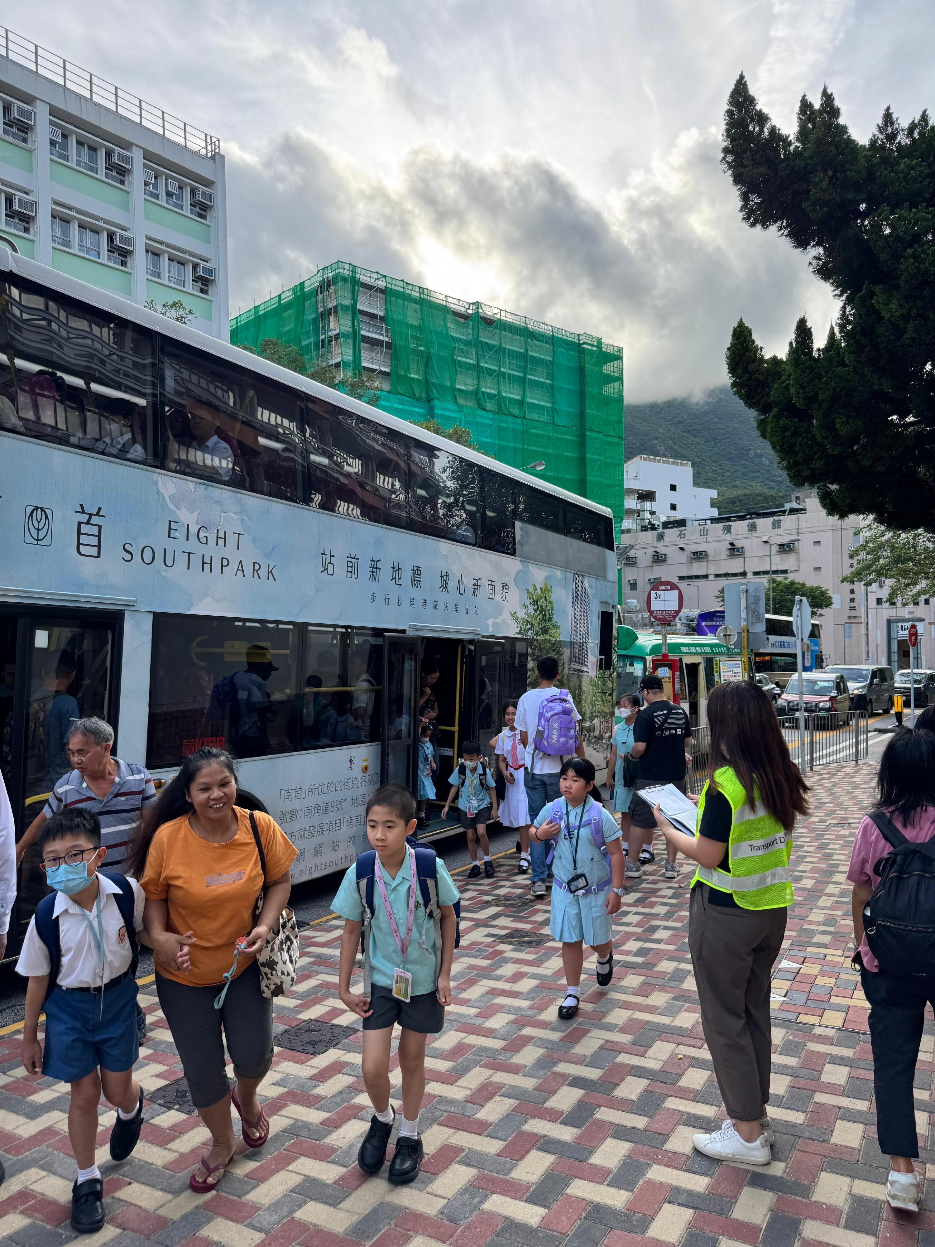 運輸署今日（九月一日）派出約100名人員，實地監察開學日港九新界主要公共運輸交匯處、車站、學校區、陸路口岸及隧道等交通情況，實時向緊急事故交通協調中心匯報，並在有需要時加強服務及實施相應交通管理措施。圖示人員（右二）在黃大仙蒲崗村道學校村監察交通情況。