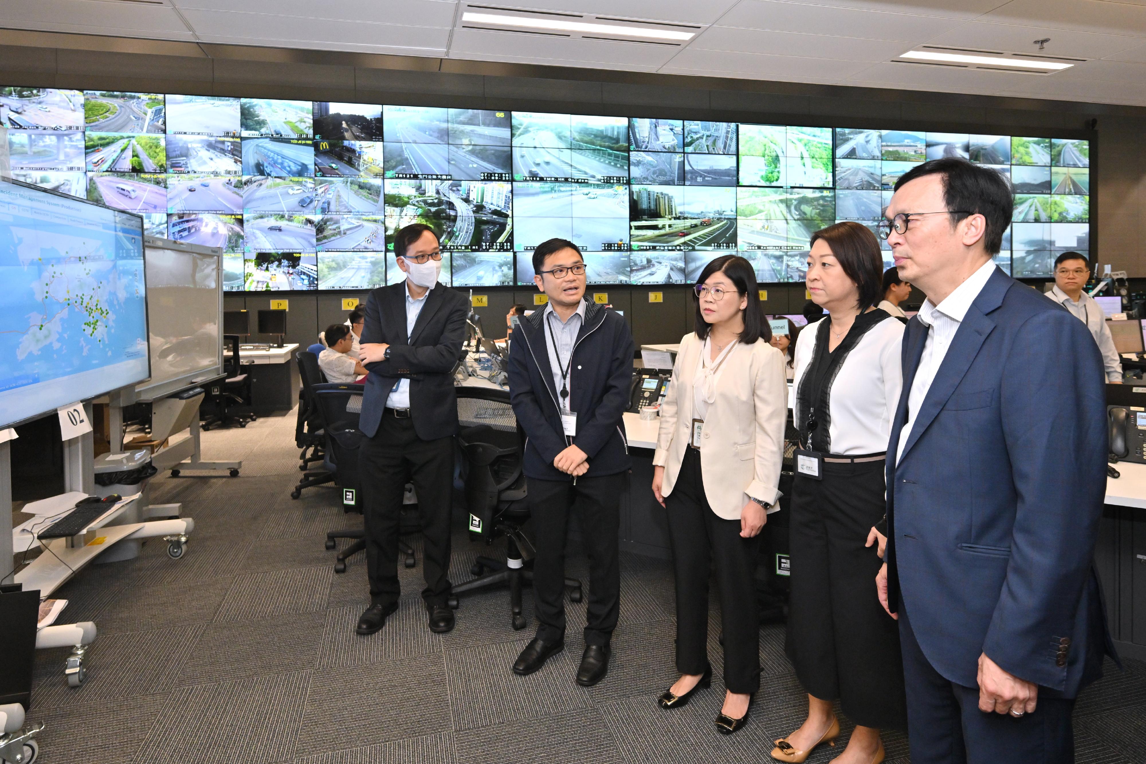 The Acting Secretary for Transport and Logistics, Mr Liu Chun-san, today (September 1) visited the Emergency Transport Co-ordination Centre of the Transport Department (TD) to take a closer look at the traffic and public transport services on the first school day. Photo shows Mr Liu (first right), accompanied by the Commissioner for Transport, Ms Angela Lee (second right), being briefed on the TD's co-ordination and monitoring work in collaboration with the Police and major public transport operators.