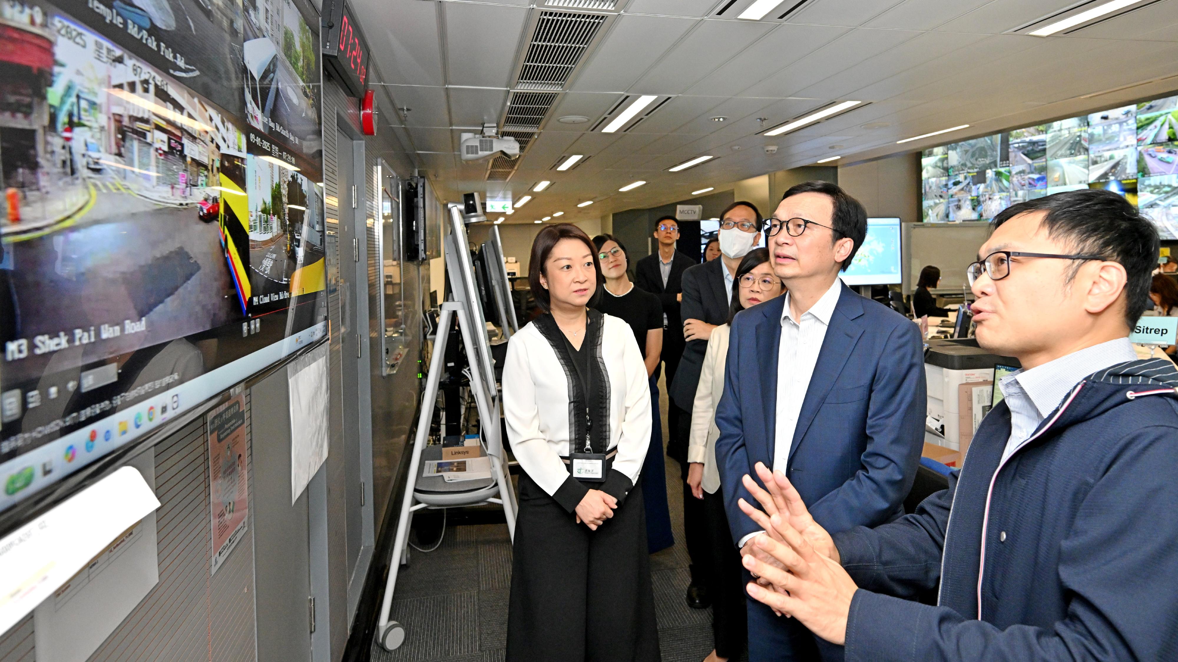 The Acting Secretary for Transport and Logistics, Mr Liu Chun-san, today (September 1) visited the Emergency Transport Co-ordination Centre of the Transport Department to take a closer look at the traffic and public transport services on the first school day. Photo shows Mr Liu (front row, centre), accompanied by the Commissioner for Transport, Ms Angela Lee (front row, left), observing the traffic conditions at school areas.