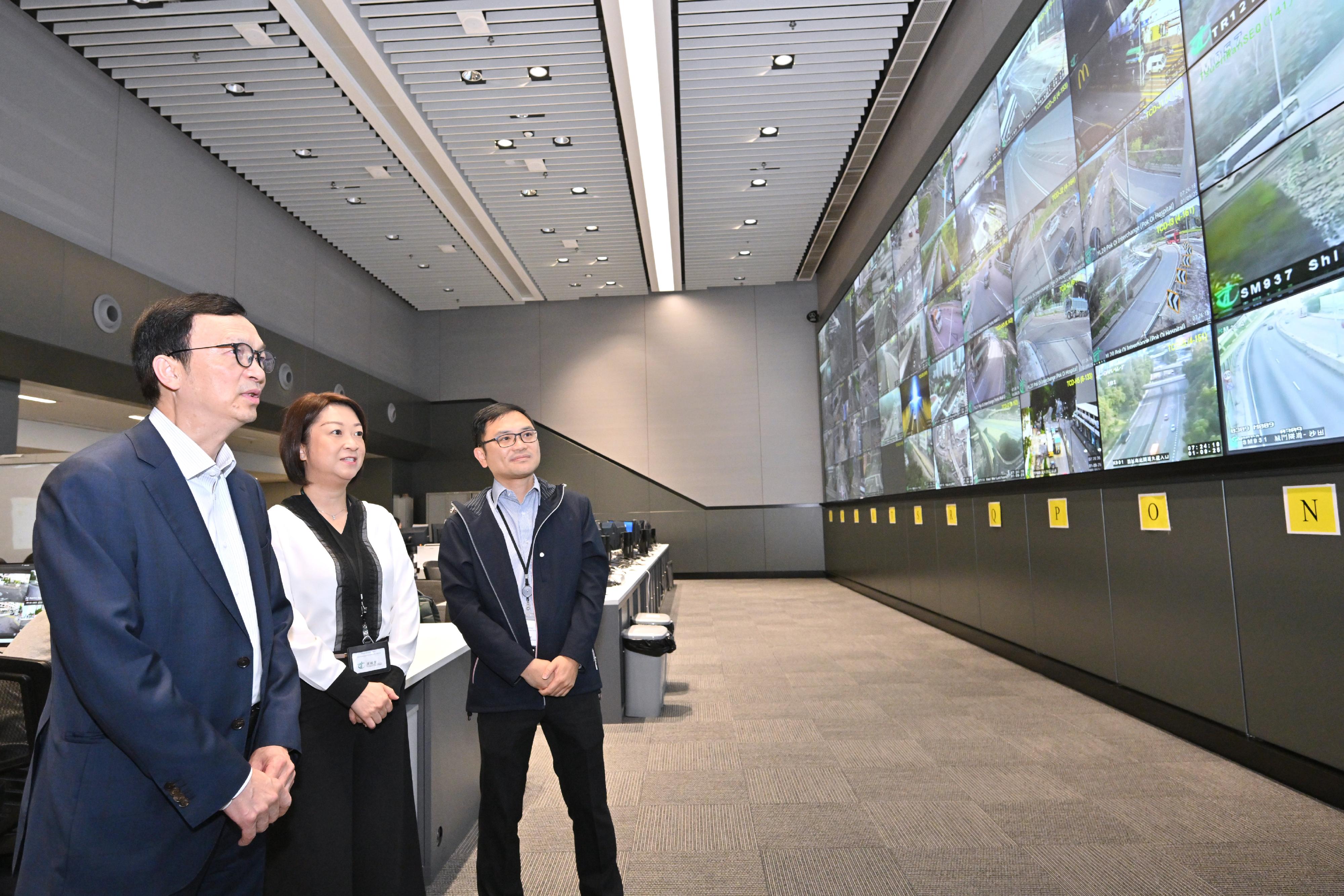 The Acting Secretary for Transport and Logistics, Mr Liu Chun-san, today (September 1) visited the Emergency Transport Co-ordination Centre of the Transport Department to take a closer look at the traffic and public transport services on the first school day. Photo shows Mr Liu (left), accompanied by the Commissioner for Transport, Ms Angela Lee (centre), learning more about the road traffic conditions of trunk roads.