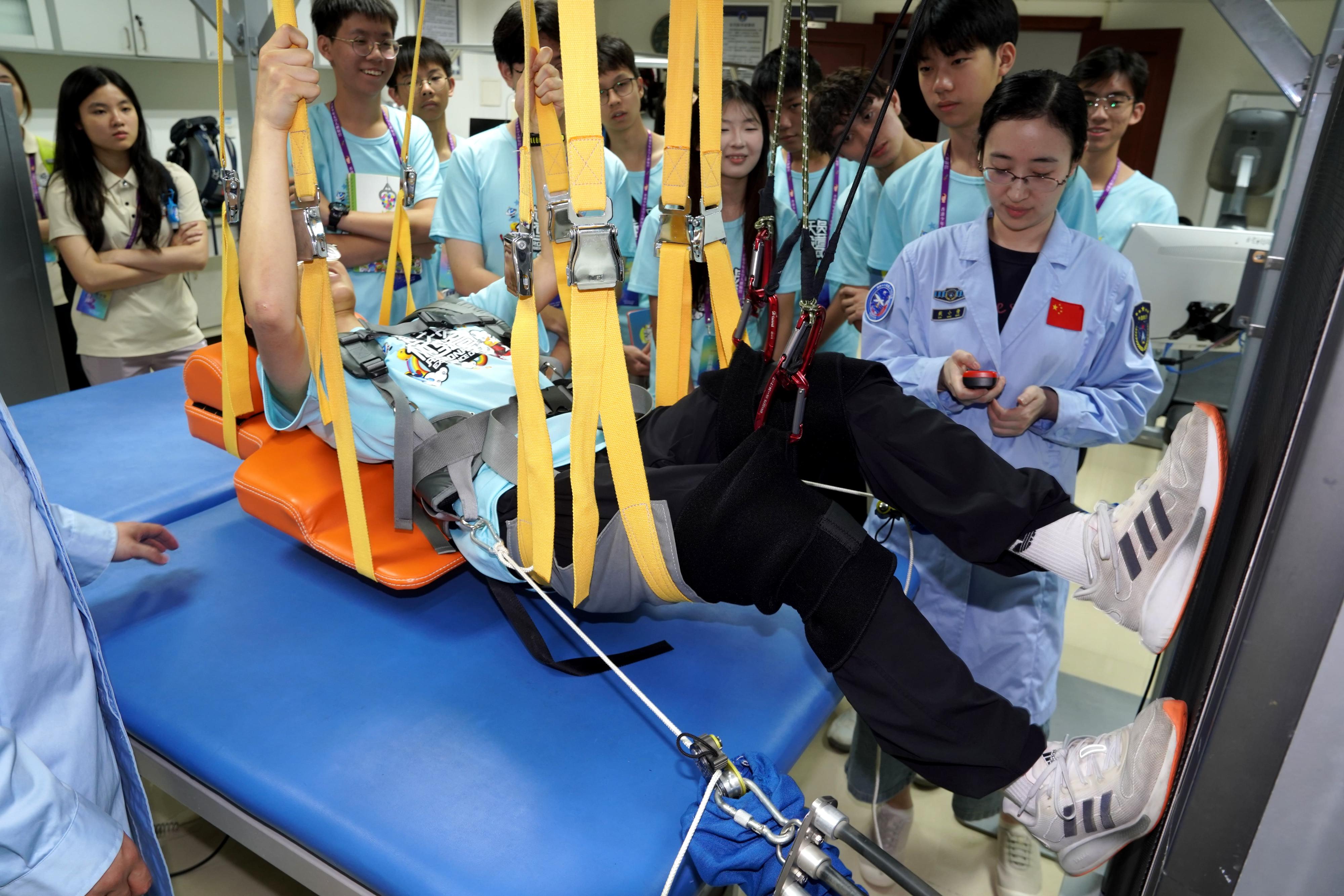 Thirty secondary school students who participated in the Young Astronaut Training Camp 2025, held from July 25 to August 2 and organised by the Hong Kong Space Museum, have completed their nine-day training camp in Beijing, Jiuquan, Xi'an, etc. Photo shows a student experiencing the bedrest exercise treadmill at the China Astronaut Research and Training Center.