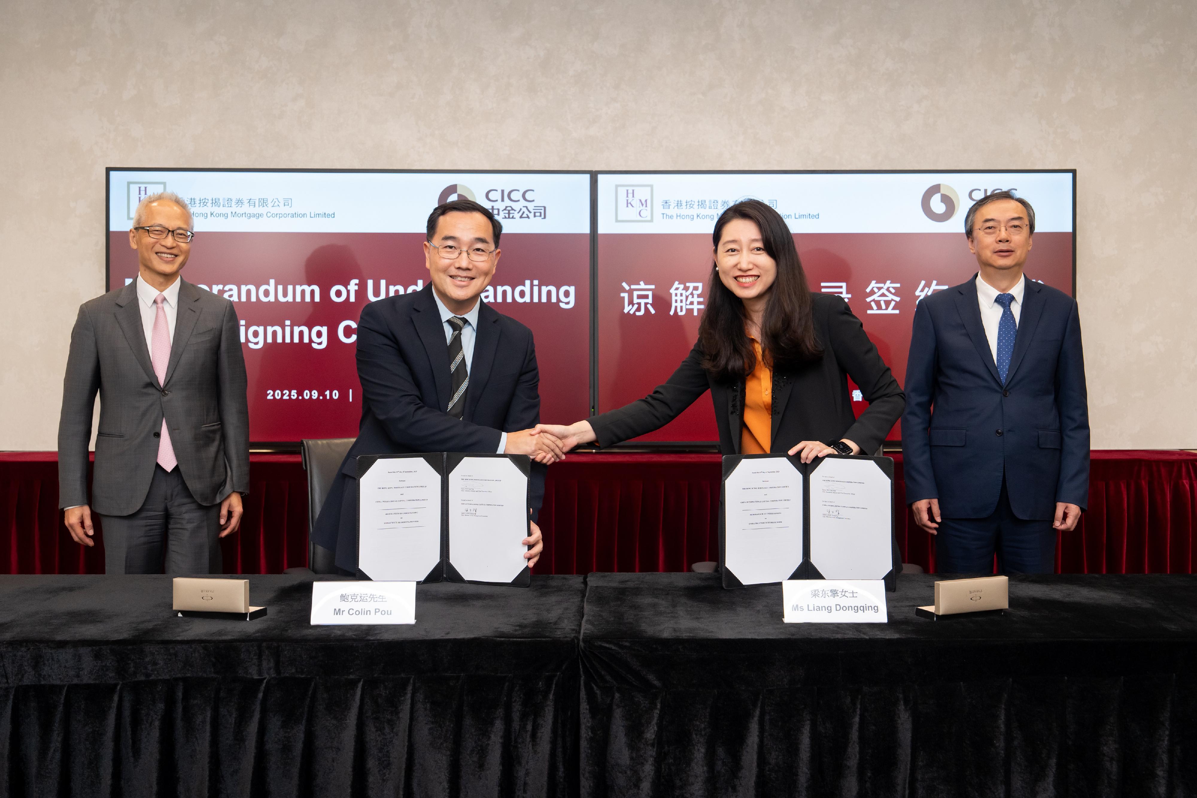 The Hong Kong Mortgage Corporation Limited (HKMC) announced that it has signed a Memorandum of Understanding (MOU) with the China International Capital Corporation Limited (CICC) in Hong Kong, China on co-operation of infrastructure financing and securitisation (IFS). Photo shows in the presence of Executive Director of the HKMC and Deputy Chief Executive of the Hong Kong Monetary Authority Mr Howard Lee (back row, left) and the Chairman of the Board of Directors and the Chairman of the Management Committee of the CICC, Mr Chen Liang (back row, right), Executive Director and the Chief Executive Officer of the HKMC, Mr Colin Pou (front row, left) and Member of the Management Committee of the CICC Ms Liang Dongqing (front row, right), signing a MOU on co-operation of the IFS.