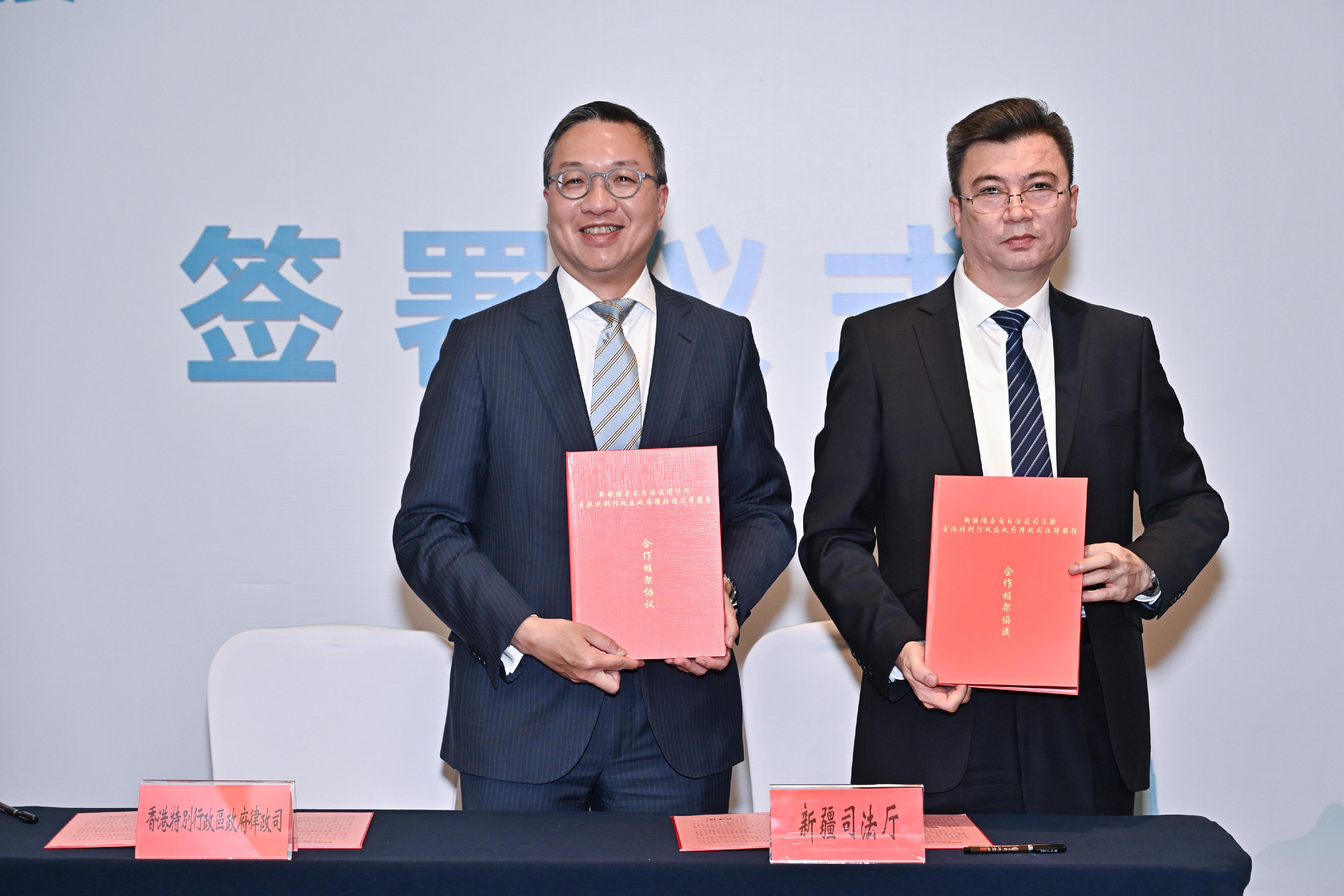 The Secretary for Justice, Mr Paul Lam, SC, leading a cross-professional delegation, attended a seminar on the role of Hong Kong's common law system in contributing to the development of the Belt and Road Initiative, organised by the Department of Justice (DoJ) and the Xinjiang Lawyers Association in Urumqi, Xinjiang on September 12. Photo shows Mr Lam (left) and the Deputy Secretary of the Party Committee and Director-General of the Department of Justice of the Xinjiang Uyghur Autonomous Region, Mr Naibijiang Yibulayimu (right), signing a framework agreement for legal service co-operation at the seminar.