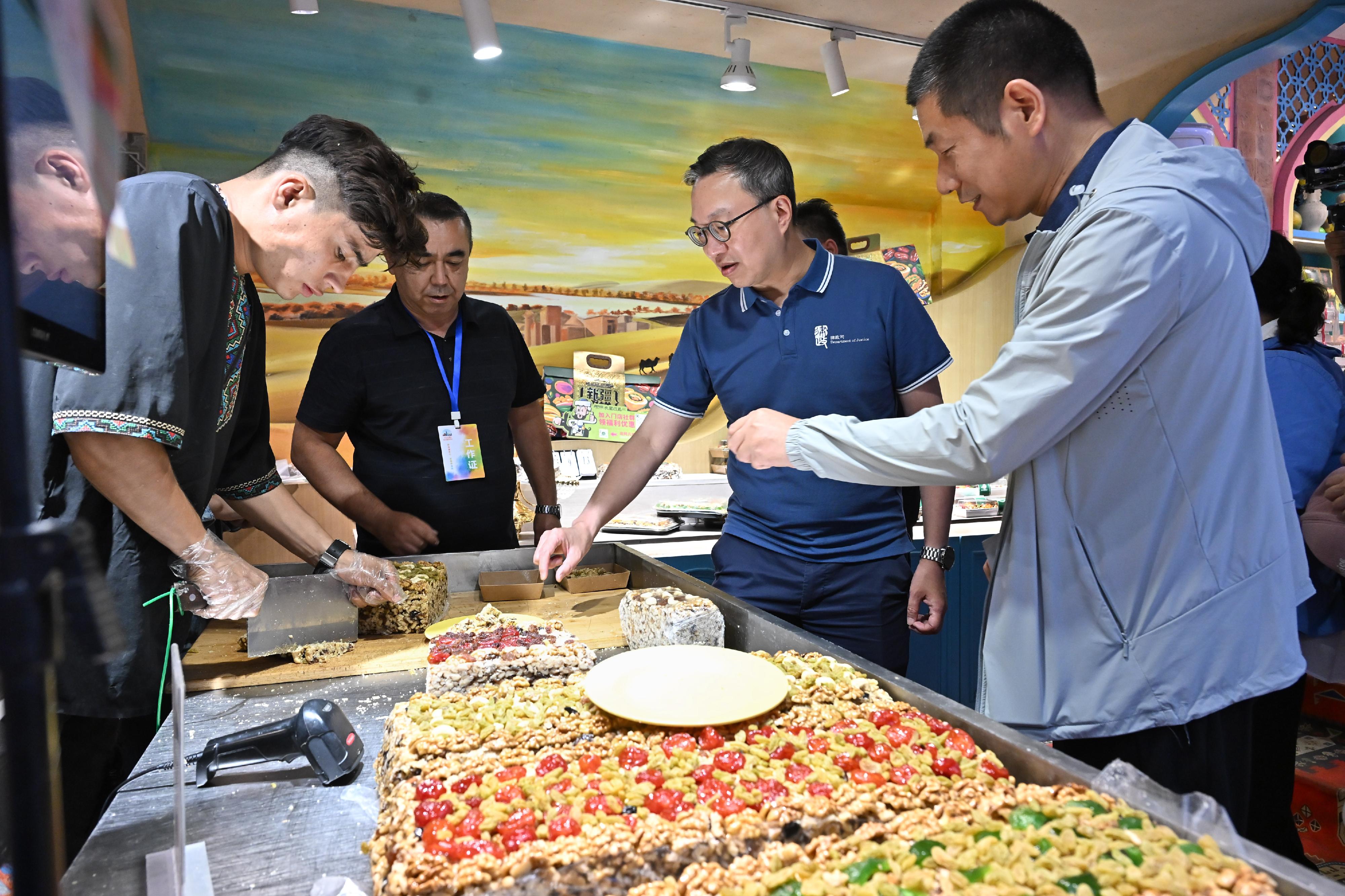 The Secretary for Justice, Mr Paul Lam, SC, leading a cross-professional delegation to visit Urumqi, Xinjiang today (September 13). Photo shows Mr Lam (second right) and the delegation visiting the Xinjiang International Grand Bazaar and tasting local snacks.