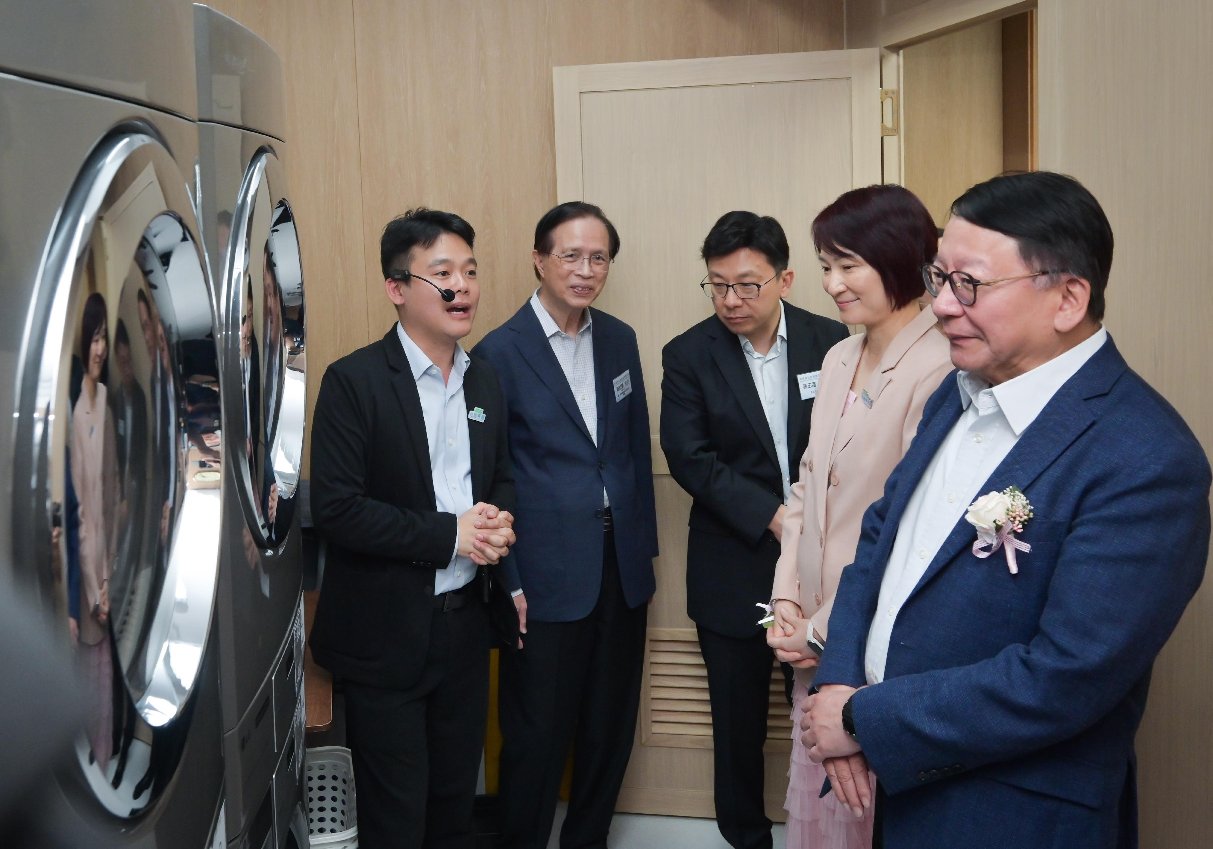 政務司司長陳國基今日（九月十五日）主持馬頭角社區客廳開幕典禮。勞工及福利局局長孫玉菡、中央人民政府駐香港特別行政區聯絡辦公室九龍工作部部長祝小東、嘉濤（香港）控股有限公司主席魏仕成、愛。聯繫慈善基金有限公司創會主席李慧琼博士、勞工及福利局常任秘書長劉焱、社會福利署署長杜永恒和愛。聯繫慈善基金有限公司董事簡志豪亦一同主禮。圖示陳國基（右一）和孫玉菡（中）參觀社區客廳的自助洗衣設施。