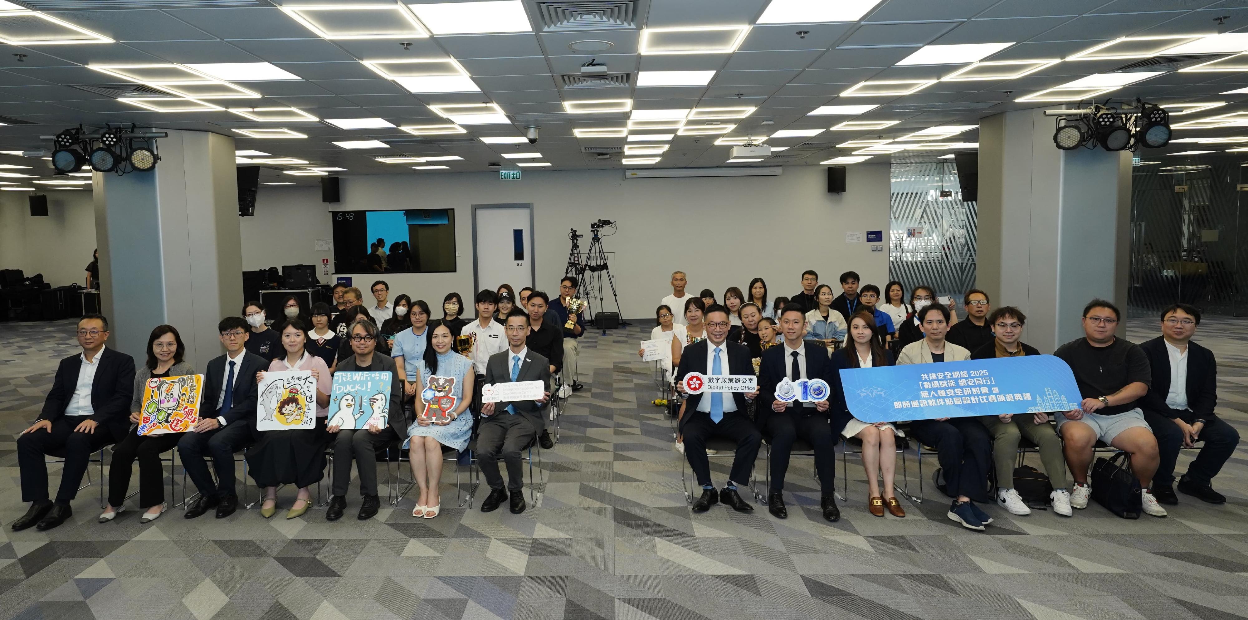 The Chief Systems Manager (Project Governance and Cybersecurity), Mr Rick Chan (first row, seventh right); the Chief Inspector of the Cyber Security and Technology Crime Bureau of the Hong Kong Police Force, Mr Felton Leung (first row, sixth right); and the General Manager of Digital Trust and Transformation Division of the Hong Kong Productivity Council, Mr Alex Chan (first row, seventh left), are pictured with guests and winners at the Build a Secure Cyberspace 2025 - "Let's Secure as we Digitalise" Drone Security Seminar and Instant Messaging Apps Stickers Design Contest Award Ceremony today (September 22).