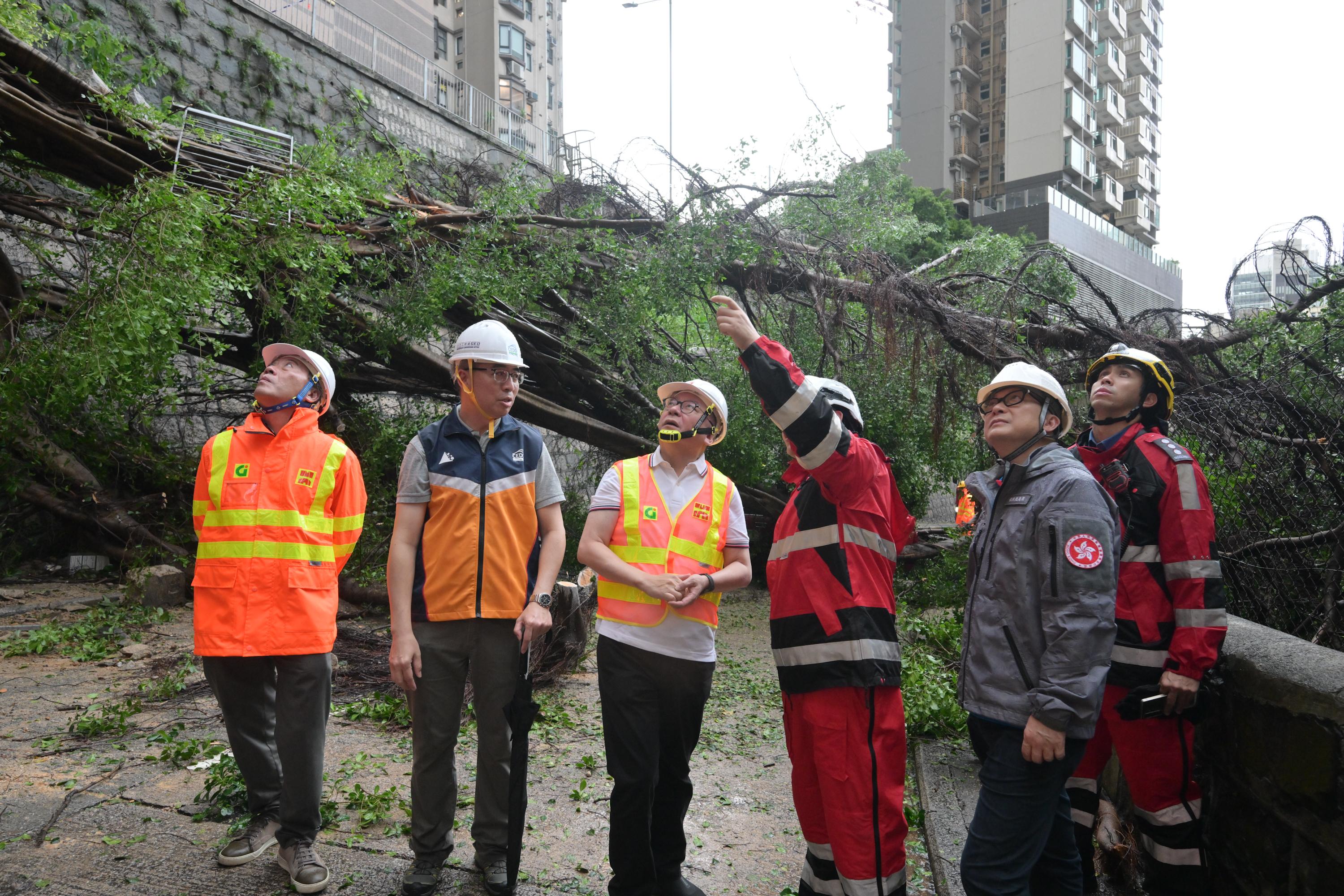 The Chief Secretary for Administration, Mr Chan Kwok-ki (third left), visited this afternoon (September 24) a site in the Central and Western District affected by fallen trees and a landslide to conduct an on-site inspection and assess the progress of cleanup and recovery efforts by government departments.


