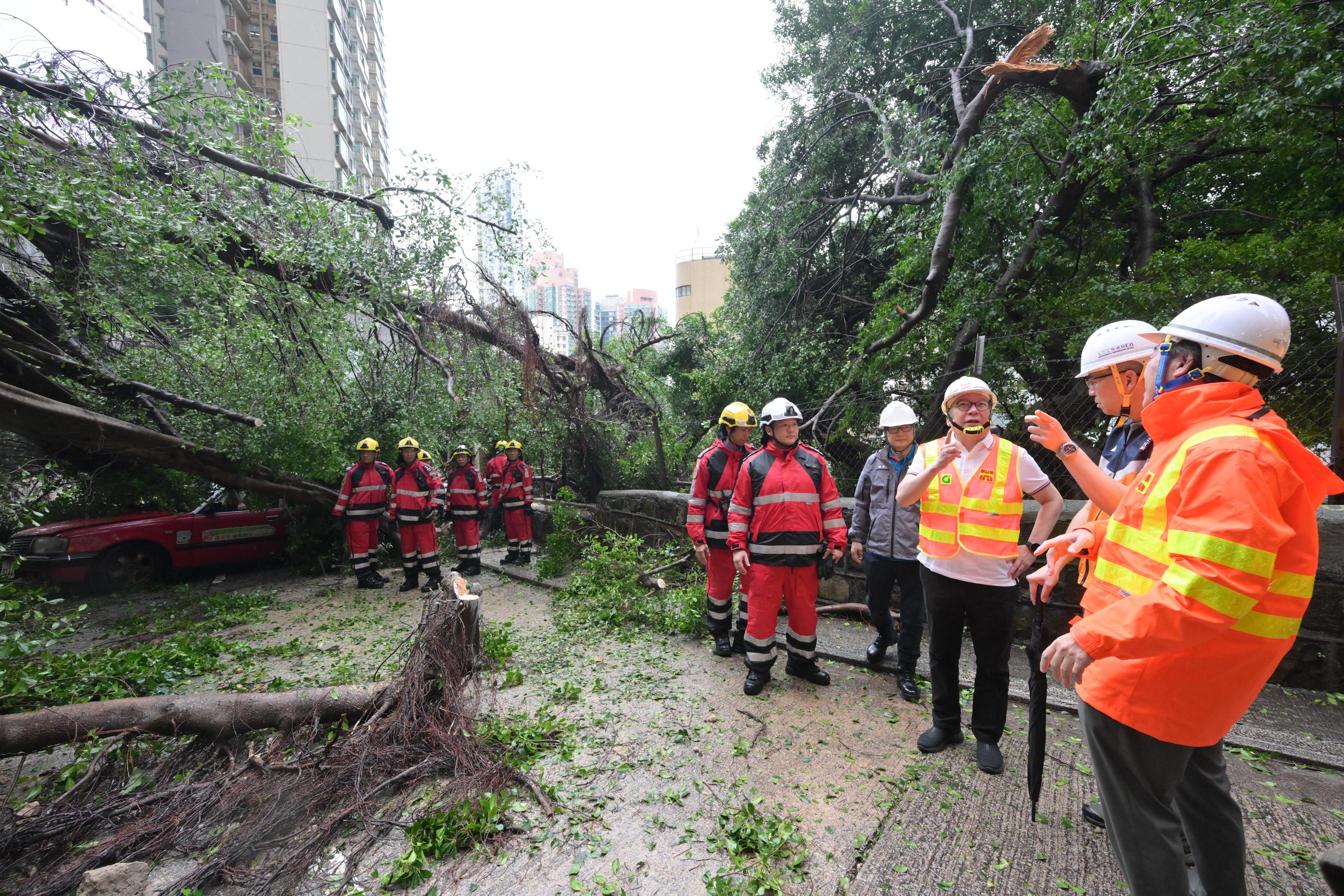 The Chief Secretary for Administration, Mr Chan Kwok-ki (third right), visited this afternoon (September 24) a site in the Central and Western District affected by fallen trees and a landslide to conduct an on-site inspection and assess the progress of cleanup and recovery efforts by government departments.
