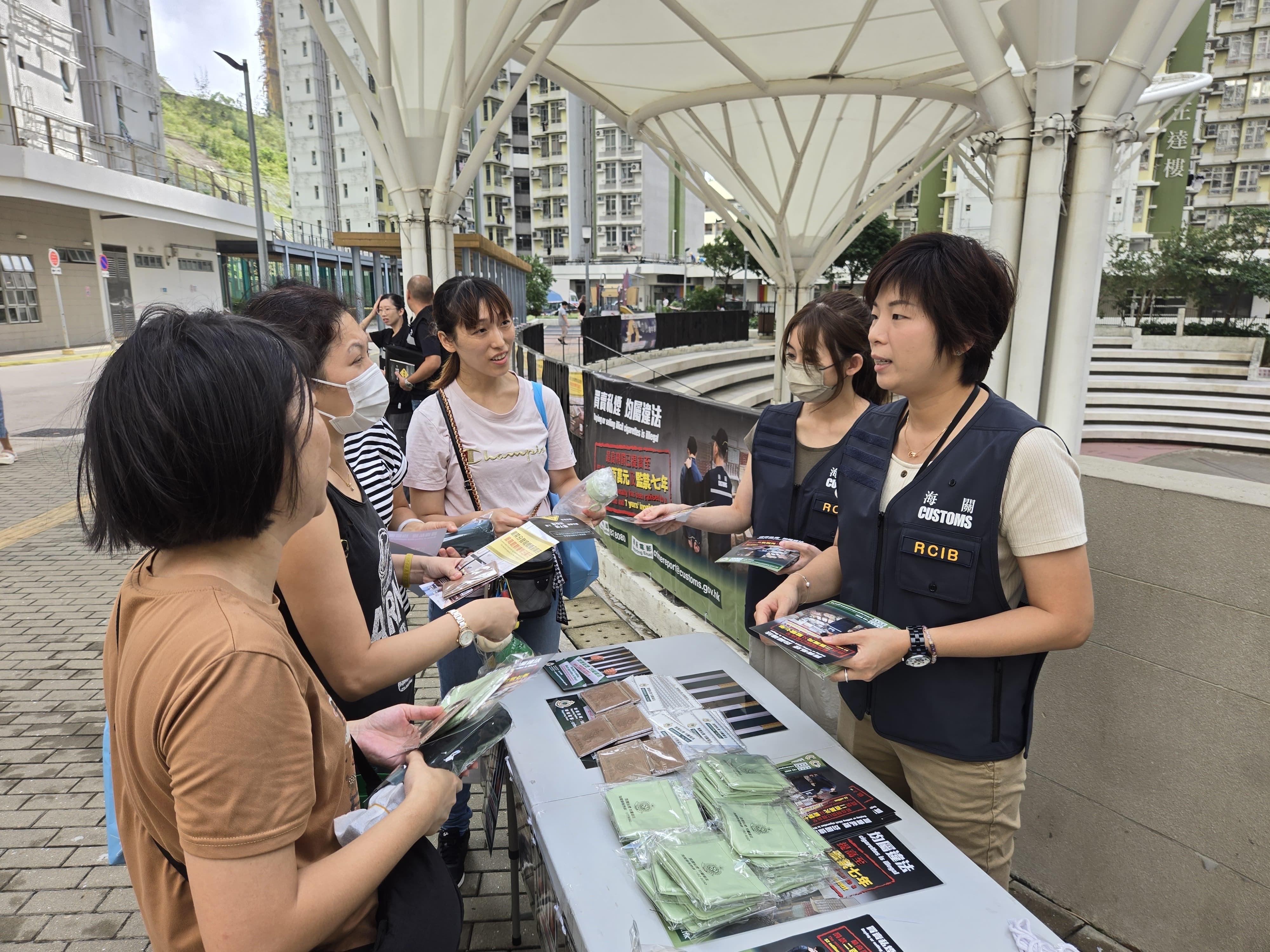 香港海關今日（九月二十六日）與觀塘區區議員、衞生署控煙酒辦公室、房屋署及社區關愛隊在觀塘安達邨進行聯合反私煙宣傳活動。圖示海關人員向居民介紹私煙相關法例的最新修訂及海關打擊私煙的工作。