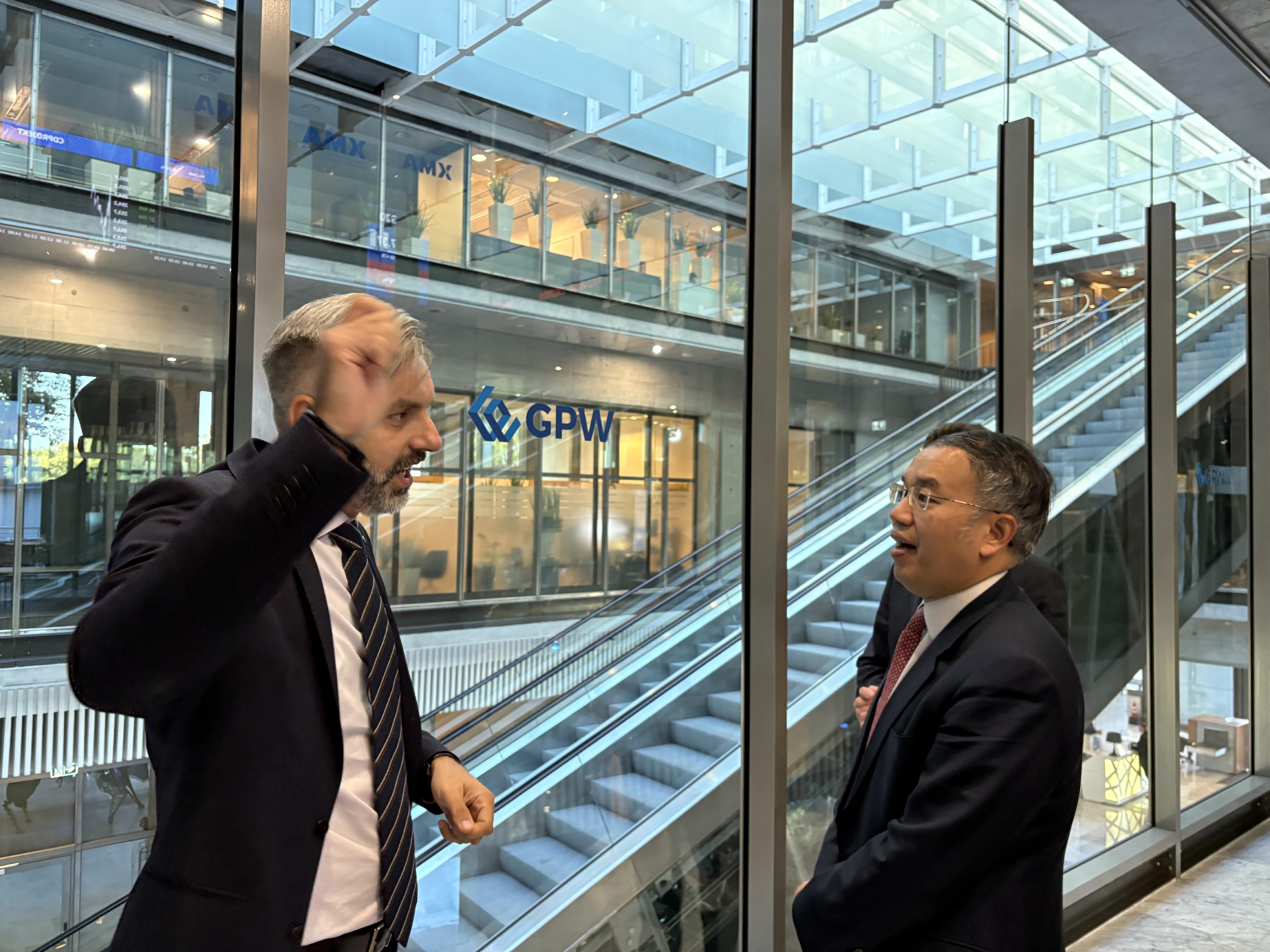 財經事務及庫務局局長許正宇(右)九月二十五日(華沙時間)在波蘭華沙到訪華沙證券交易所時,聽取有關交易所歷史的介紹。