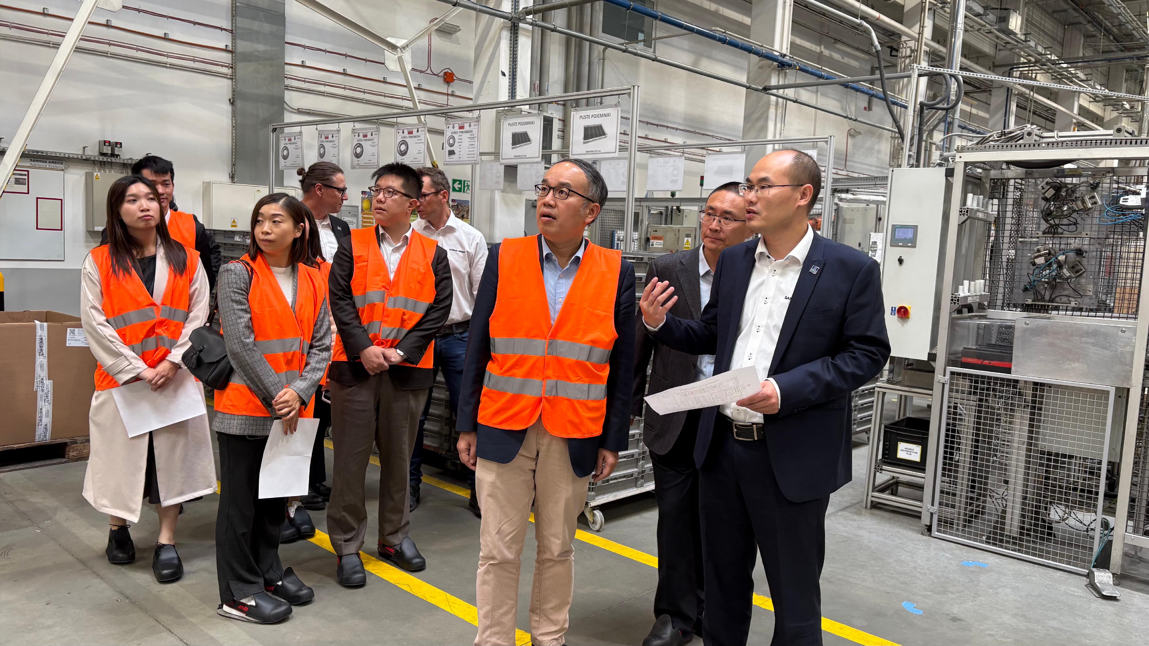 財經事務及庫務局局長許正宇(右三)九月二十六日(蒂黑時間)在波蘭蒂黑參觀三花亞威科波蘭電器設備有限公司的廠房。圖示三花亞威科歐洲行政總裁劉世峰(右一)為他講解廠房運作。