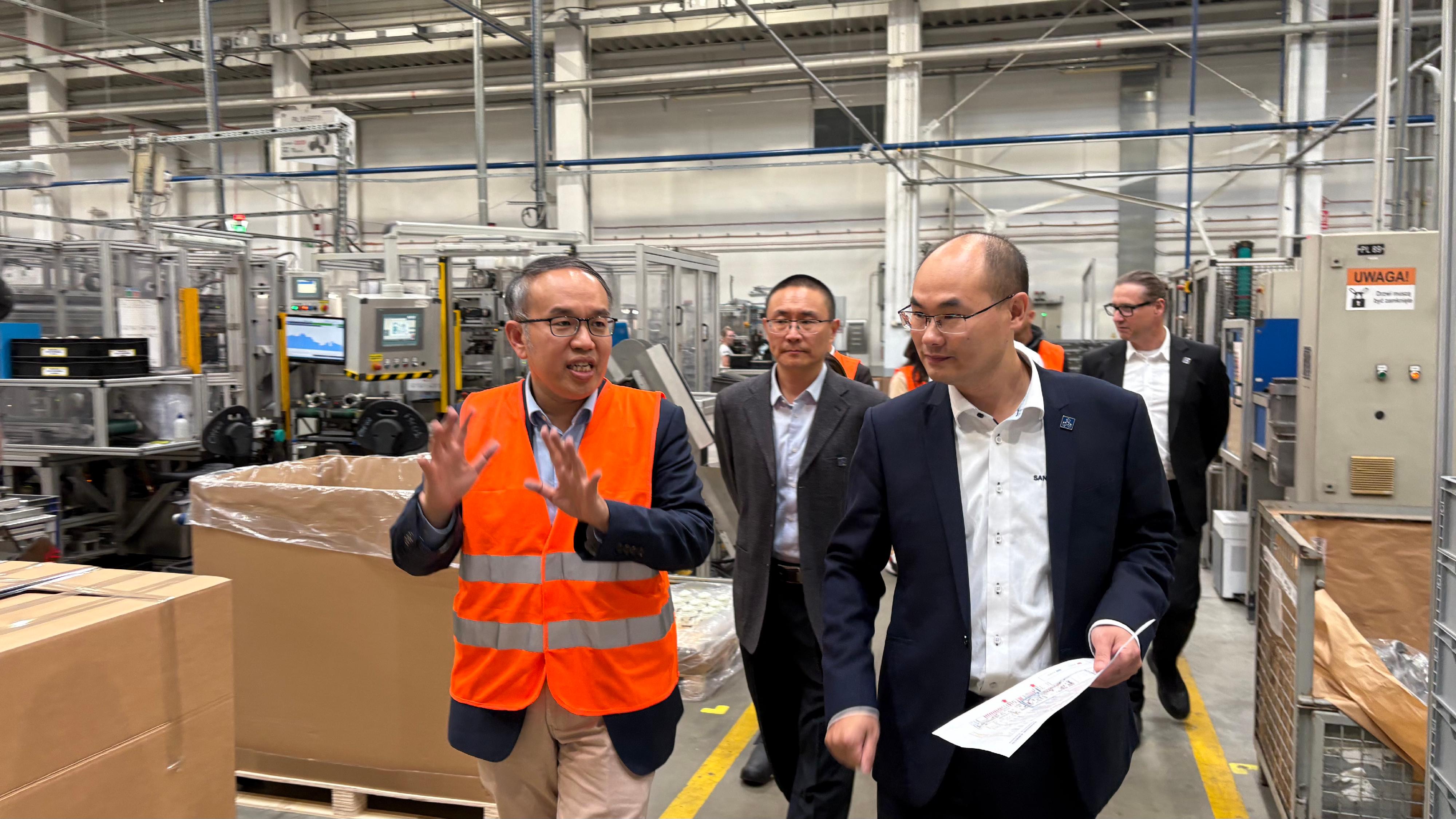 財經事務及庫務局局長許正宇(左一)九月二十六日(蒂黑時間)在波蘭蒂黑參觀三花亞威科波蘭電器設備有限公司的廠房。圖示三花亞威科歐洲行政總裁劉世峰(右二)為他講解廠房運作。
