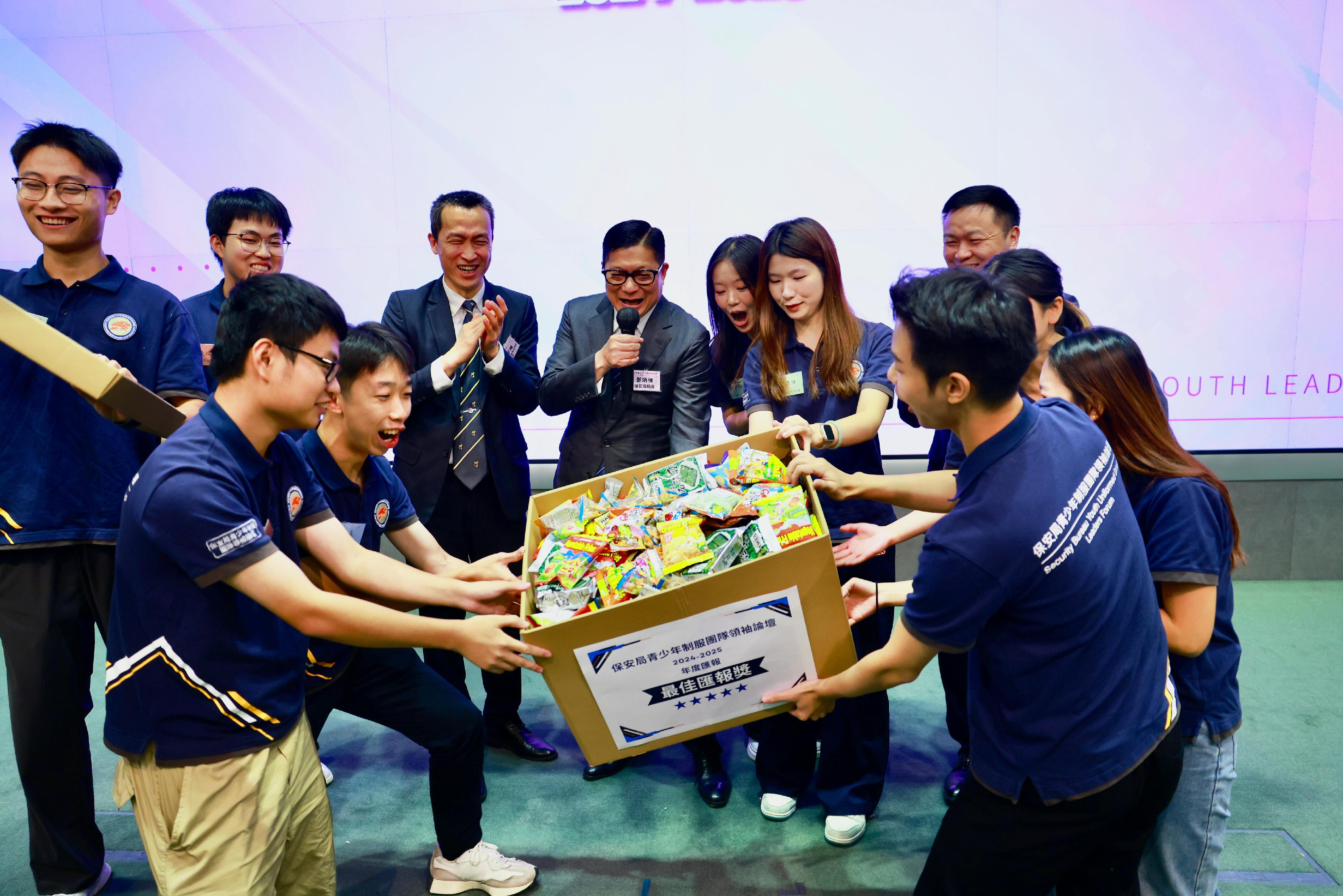 The annual review of the Security Bureau Youth Uniformed Group Leaders Forum was held at the Central Government Offices today (September 27), for youth members from Hong Kong, Shenzhen and Macao to reflect on their experiences and learning outcomes over the past year. Photo shows the Secretary for Security, Mr Tang Ping-keung, presenting a gift to the best presentation team.