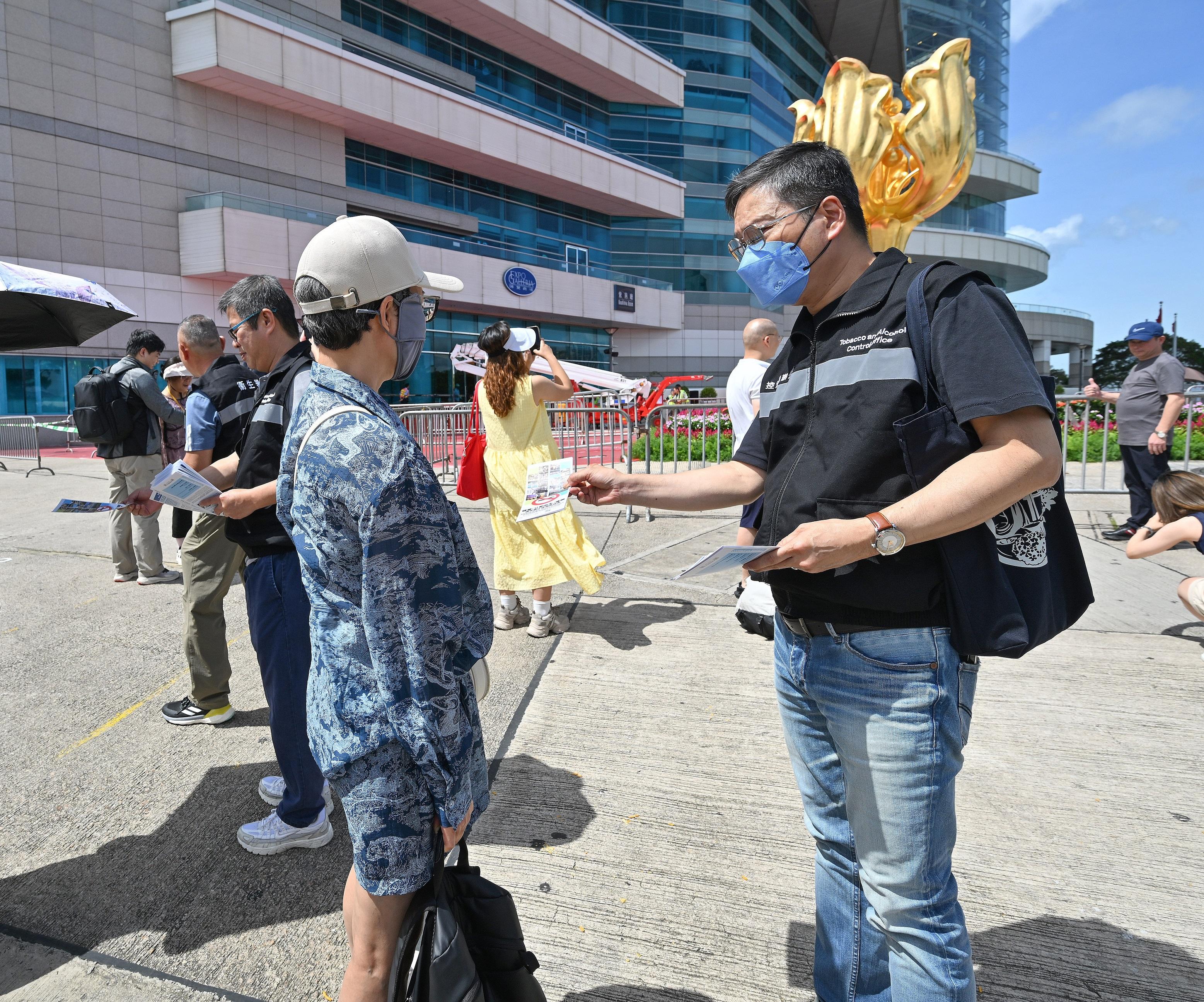 The Tobacco and Alcohol Control Office (TACO) of the Department of Health today (September 30) announced that it will increase its publicity efforts in tourist areas this week to remind both members of the public and visitors to comply with Hong Kong's tobacco control laws and foster a smoke-free environment as the community celebrates the National Day and the Mid-Autumn Festival. Photo shows TACO officers distributing pamphlets on tobacco control measures to tourists at Golden Bauhinia Square in Wan Chai.