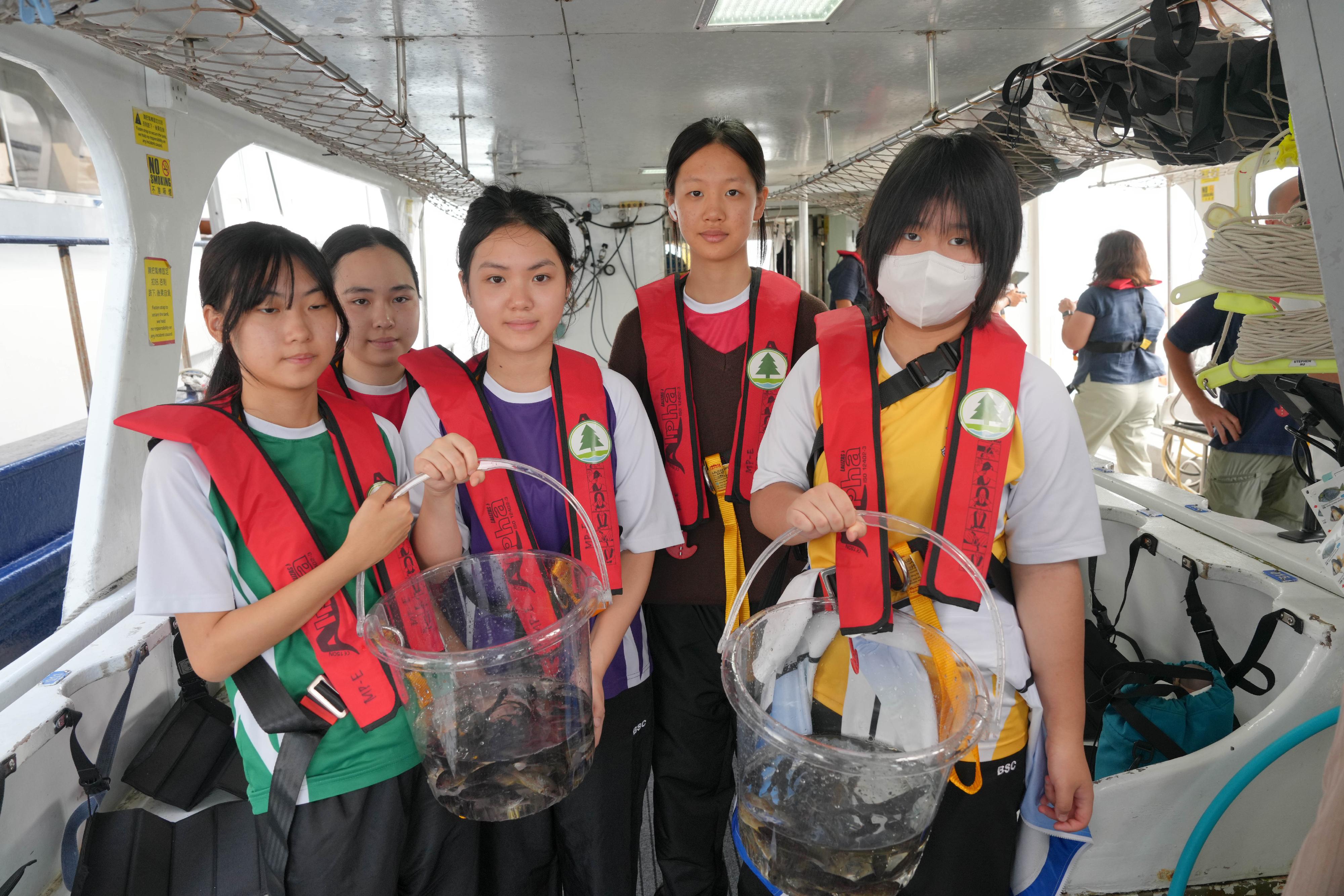 The Agriculture, Fisheries and Conservation Department (AFCD), together with secondary school teachers and students, representatives from the Hong Kong Fishermen Consortium and the Ocean Park Conservation Foundation Hong Kong conducted a restocking activity in Yan Chau Tong Marine Park today (October 9), with an aim to restore and enhance aquatic resources as well as raise students' awareness of the conservation of aquatic resources and the need to improve aquatic habitats, and to increase their knowledge of the local fisheries industry. Photo shows students experiencing the release of juvenile fish first-hand.