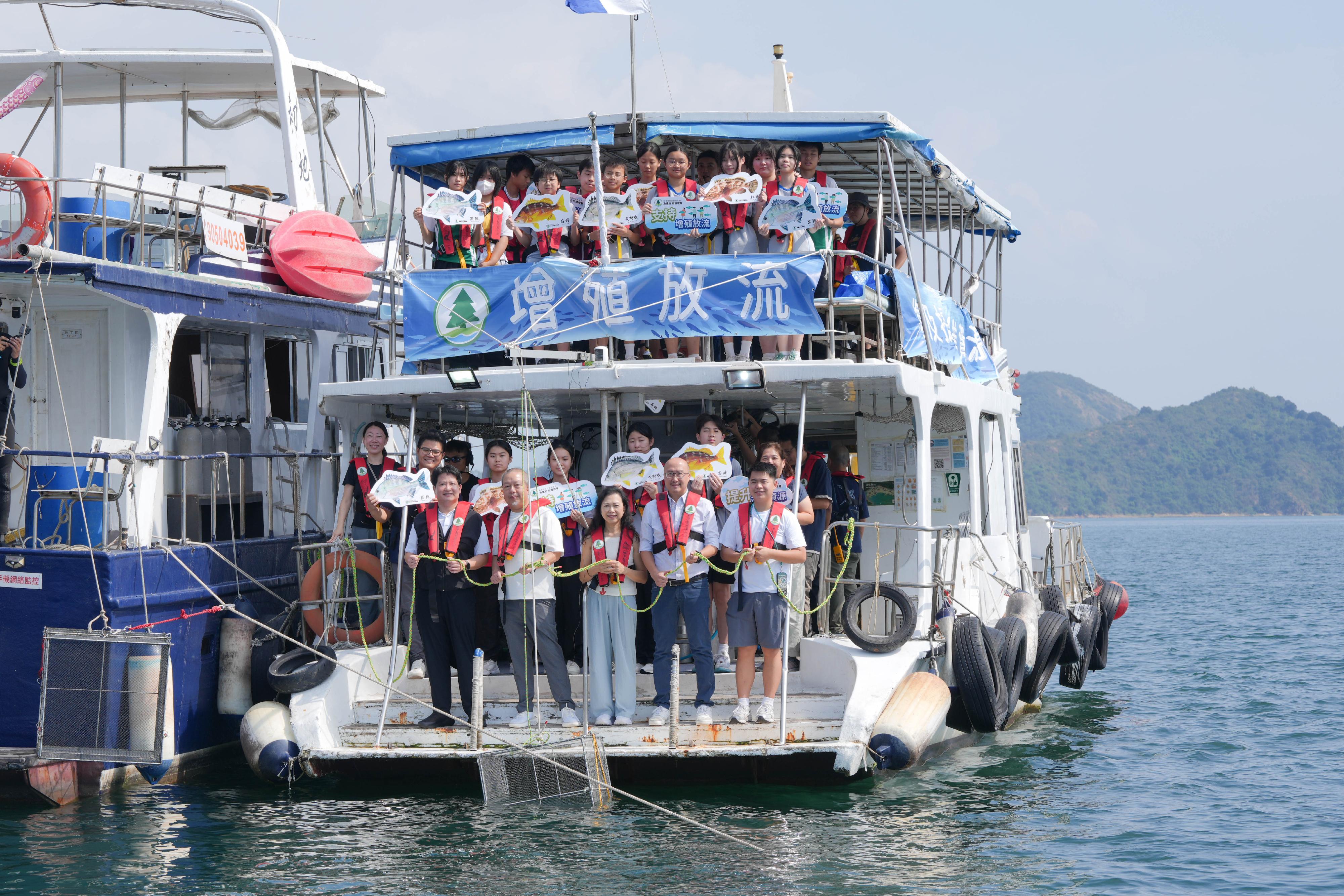 The Agriculture, Fisheries and Conservation Department (AFCD), together with secondary school teachers and students, representatives from the Hong Kong Fishermen Consortium and the Ocean Park Conservation Foundation Hong Kong conducted a restocking activity in Yan Chau Tong Marine Park (YCTMP) today (October 9), with an aim to restore and enhance aquatic resources as well as raise students' awareness of the conservation of aquatic resources and the need to improve aquatic habitats, and to increase their knowledge of the local fisheries industry. Photo shows the Assistant Director (Fisheries and Marine Conservation) of the AFCD, Dr Jim Chu (front row, second left), with representatives from the Hong Kong Fishermen Consortium and the Ocean Park Conservation Foundation Hong Kong, as well as teachers and students at the restocking location in YCTMP.