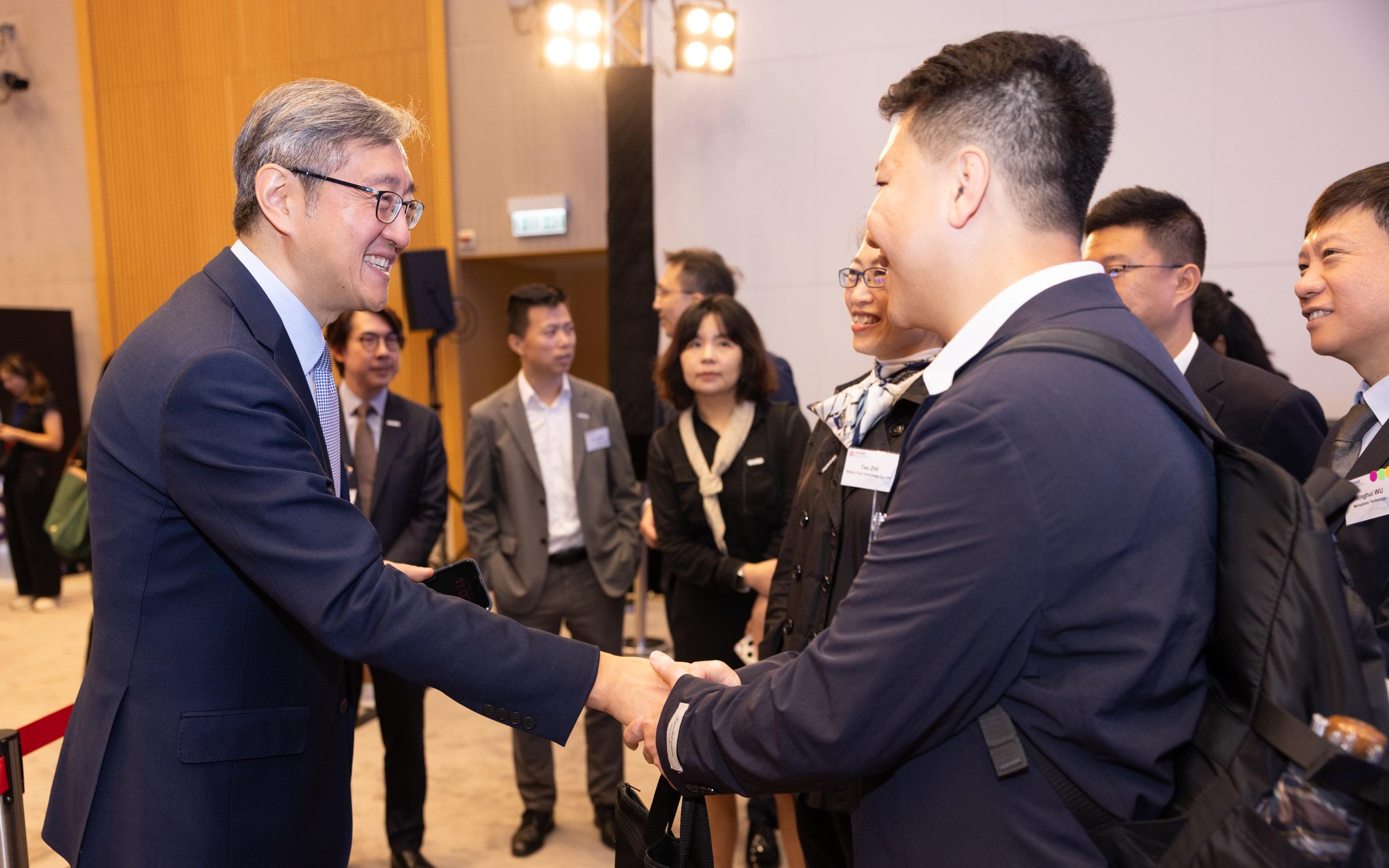 The Office for Attracting Strategic Enterprises (OASES) held the OASES Enterprises Signing Ceremony today (October 9). Photo shows the Director-General of OASES, Mr Peter Yan (first left), interacting with representatives of a strategic enterprise.