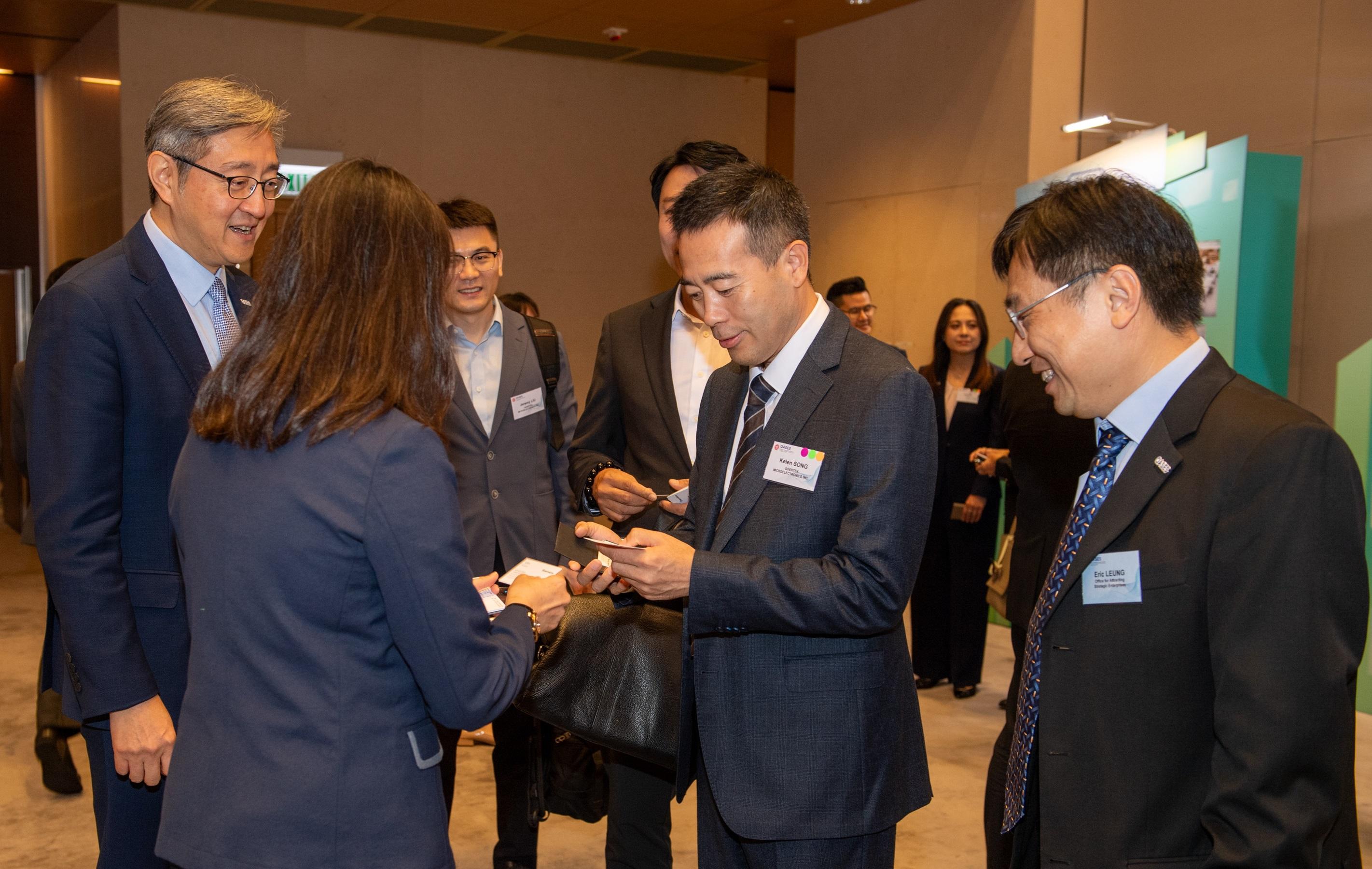 The Office for Attracting Strategic Enterprises (OASES) held the OASES Enterprises Signing Ceremony today (October 9). Photo shows the Director-General of OASES, Mr Peter Yan (first left), interacting with representatives of a strategic enterprise.