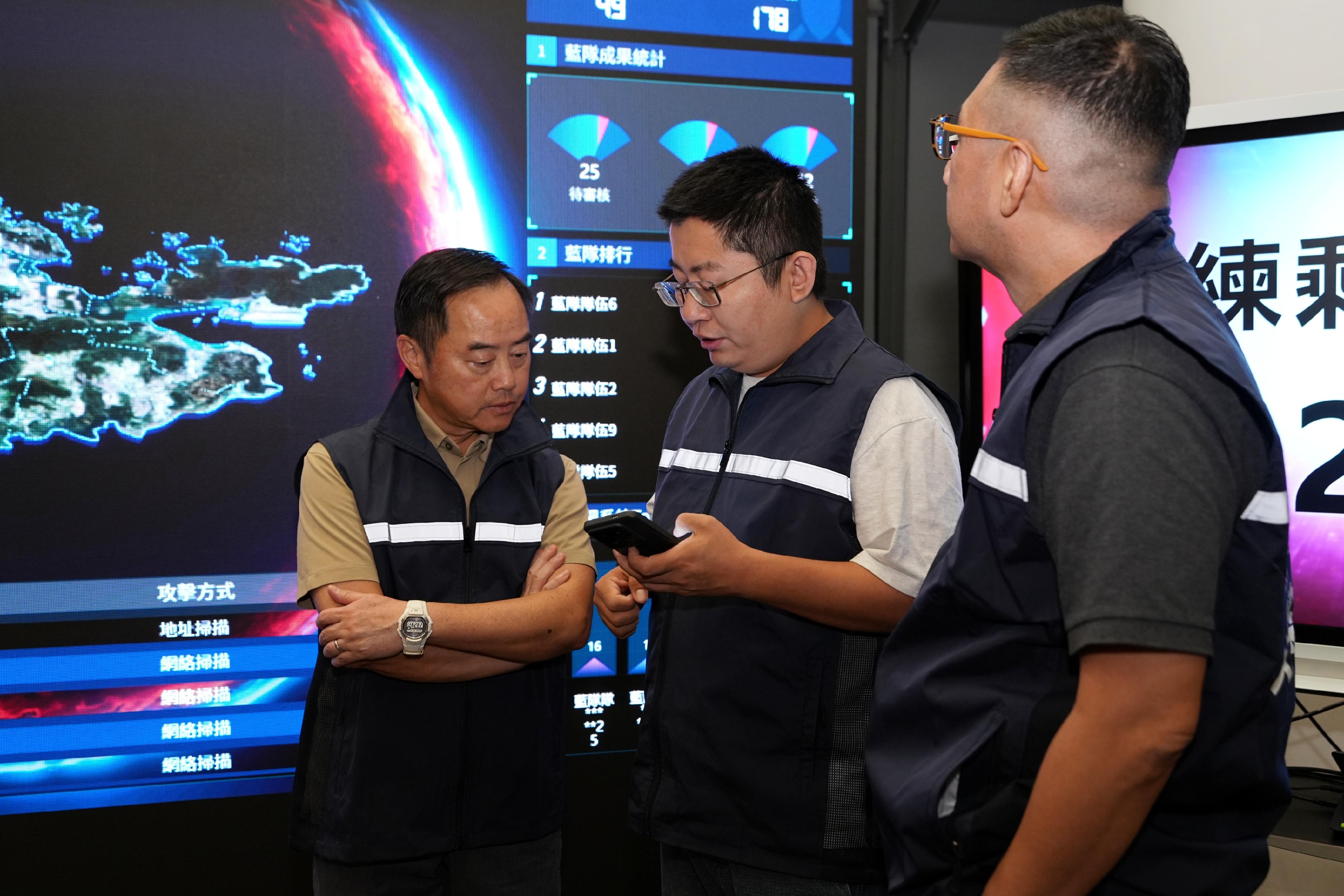 During the Hong Kong Cybersecurity Attack and Defence Drill 2025, the Commissioner for Digital Policy, Mr Tony Wong (left), visited the venue and was briefed on the exercise's progress.
