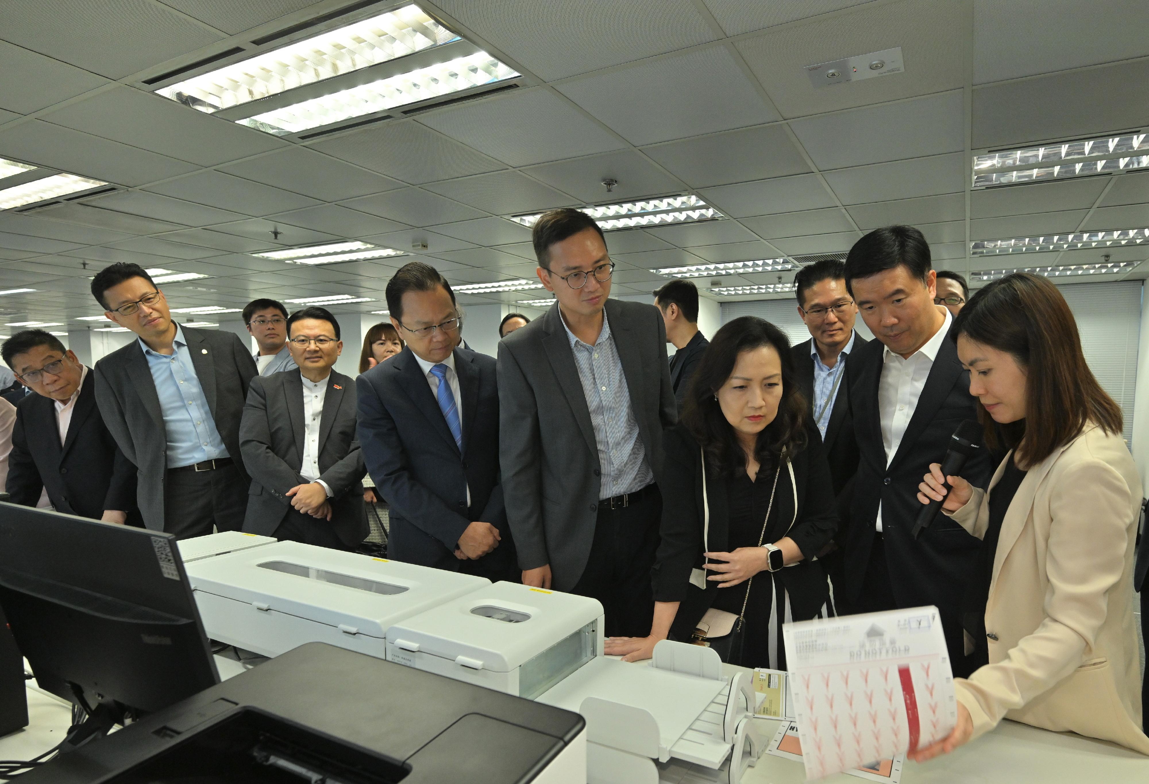 The Registration and Electoral Office (REO) today (October 13) hosted a briefing and demonstration session for Legislative Council (LegCo) Members on the operation of the electronic counting system to be adopted in the functional constituencies in the LegCo General Election this year. Photo shows an REO representative demonstrating to LegCo Members the operation of the high speed scanner.