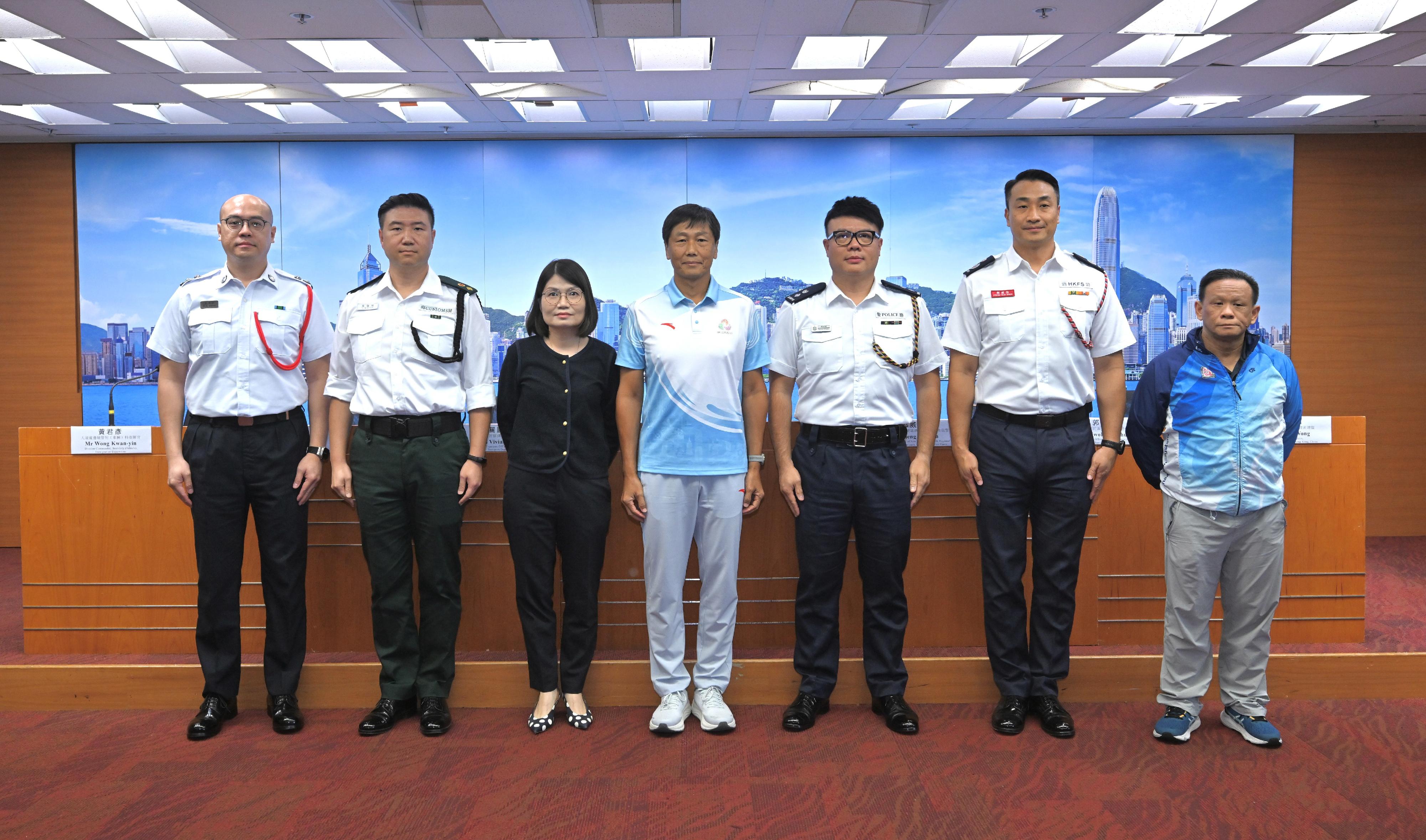 全國運動會香港賽區統籌辦公室（全運會統籌辦）今日（十月十四日）聯同運輸署、香港警務處、香港海關、消防處、入境事務處和中國香港單車總會代表舉行跨部門記者會，簡介在十一月八日舉行的第十五屆全國運動會自行車（公路）賽（男子個人賽）的相關安排。圖示全運會統籌辦主任楊德強（中）、運輸署首席運輸主任／新界關國恩（左三）、香港警務處新界南總區總部（行動）高級警司鄭威鍵（右三）、香港海關跨境橋岸科總指揮官袁偉明（左二）、香港消防處高級消防區長（全國運動會支援）郭威信（右二）、入境事務處（邊境管制）車輛科指揮官黃君彥（左一）和中國香港單車總會技術總監黃志如（右一）出席記者會。