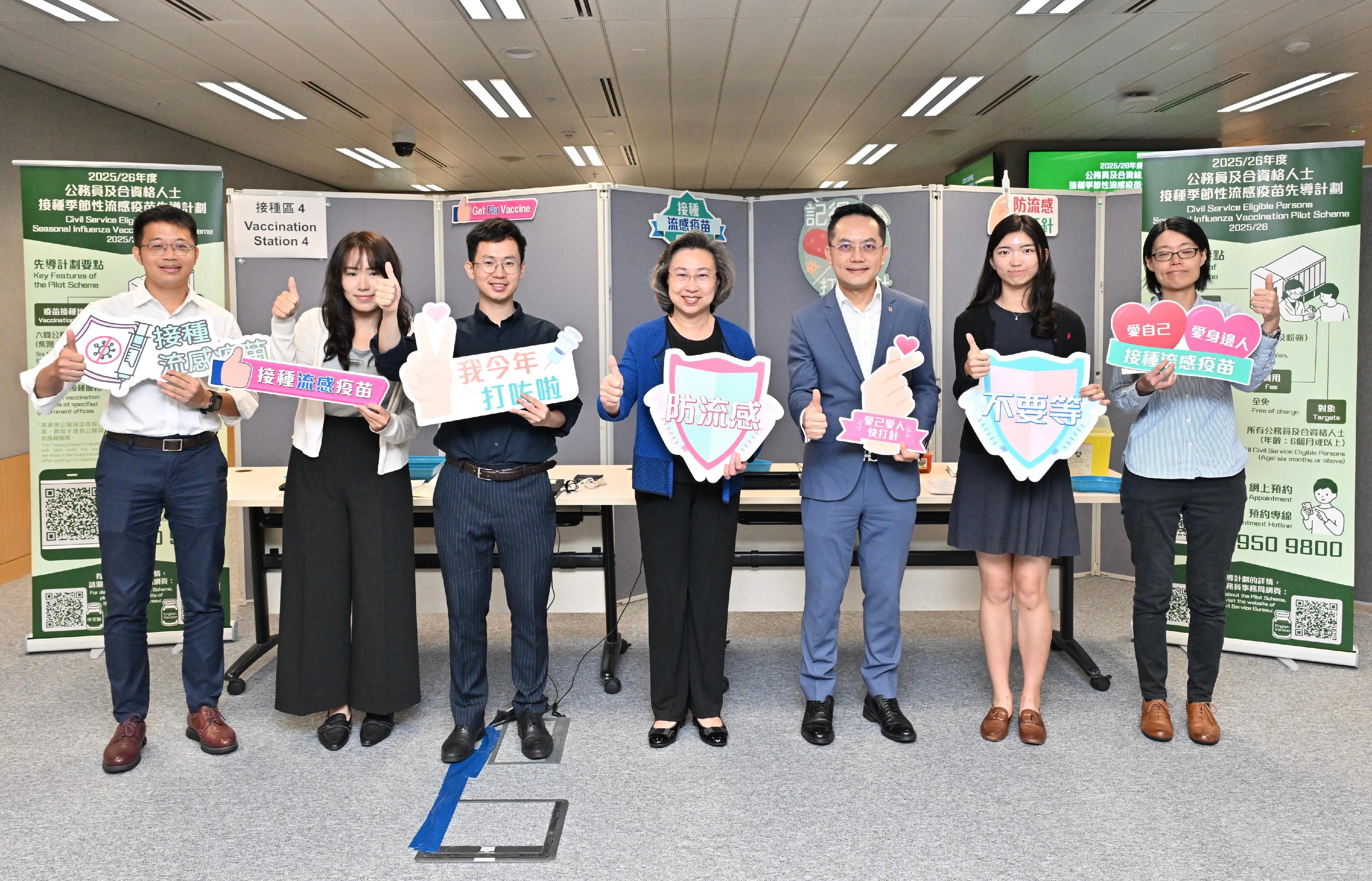 為方便和鼓勵公務員接種流感疫苗，公務員事務局聯同衞生署今年繼續推行公務員及合資格人士接種季節性流感疫苗先導計劃，並首次以試點形式在指定政府辦公大樓提供外展接種服務。圖示公務員事務局局長楊何蓓茵（中）及衞生署署長林文健（右三）今日（十月十五日）上午在政府總部設立的外展站與接種流感疫苗的公務員合照。
