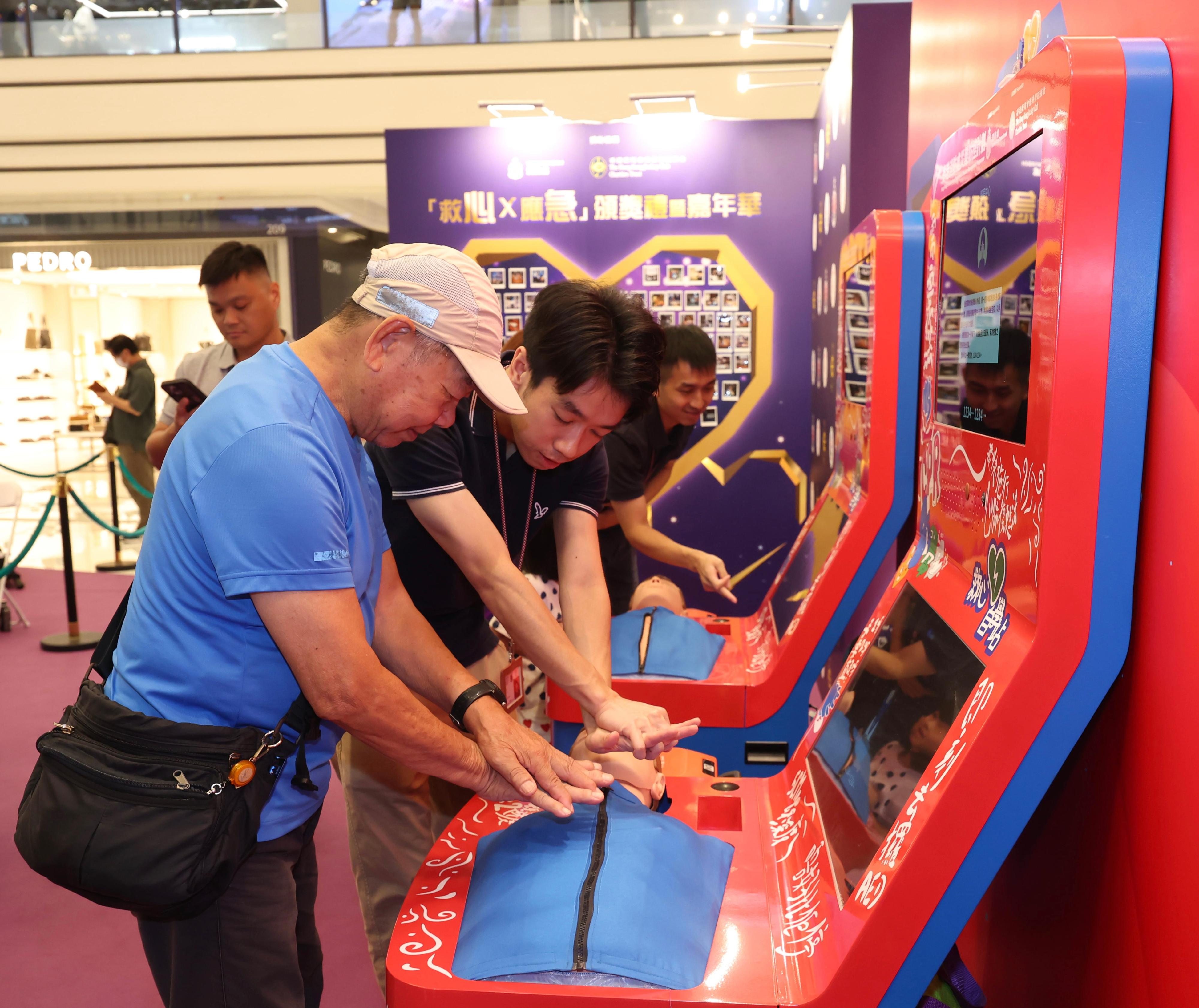 The Fire Services Department held the Save Lives x Emergency Response Ceremony cum Carnival today (October 18). Photo shows a member of the public learning to perform cardiopulmonary resuscitation (CPR) and to use an automated external defibrillator (AED) at a CPR & AED Self-learning Kiosk.